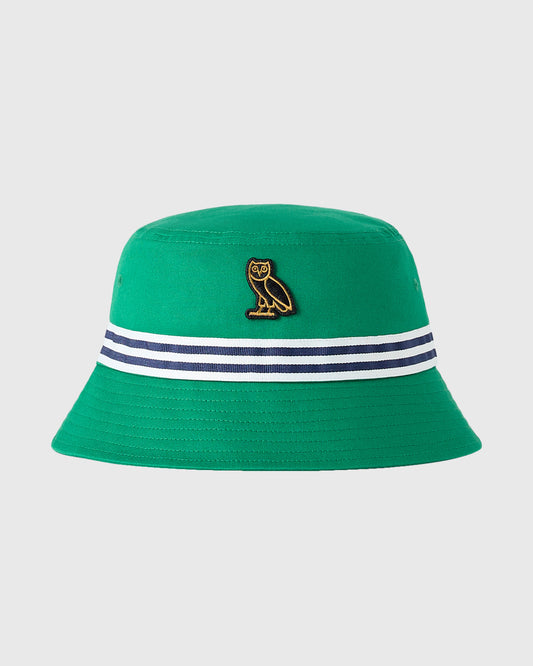 Green bucket hat with gold owl emblem and navy-white striped band around crown.