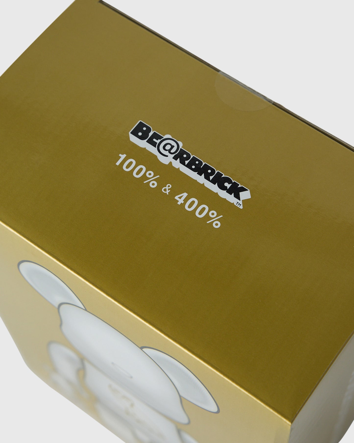 Gold box with BE@RBRICK logo and "100% & 400%" text, pearl white figures visible below.
