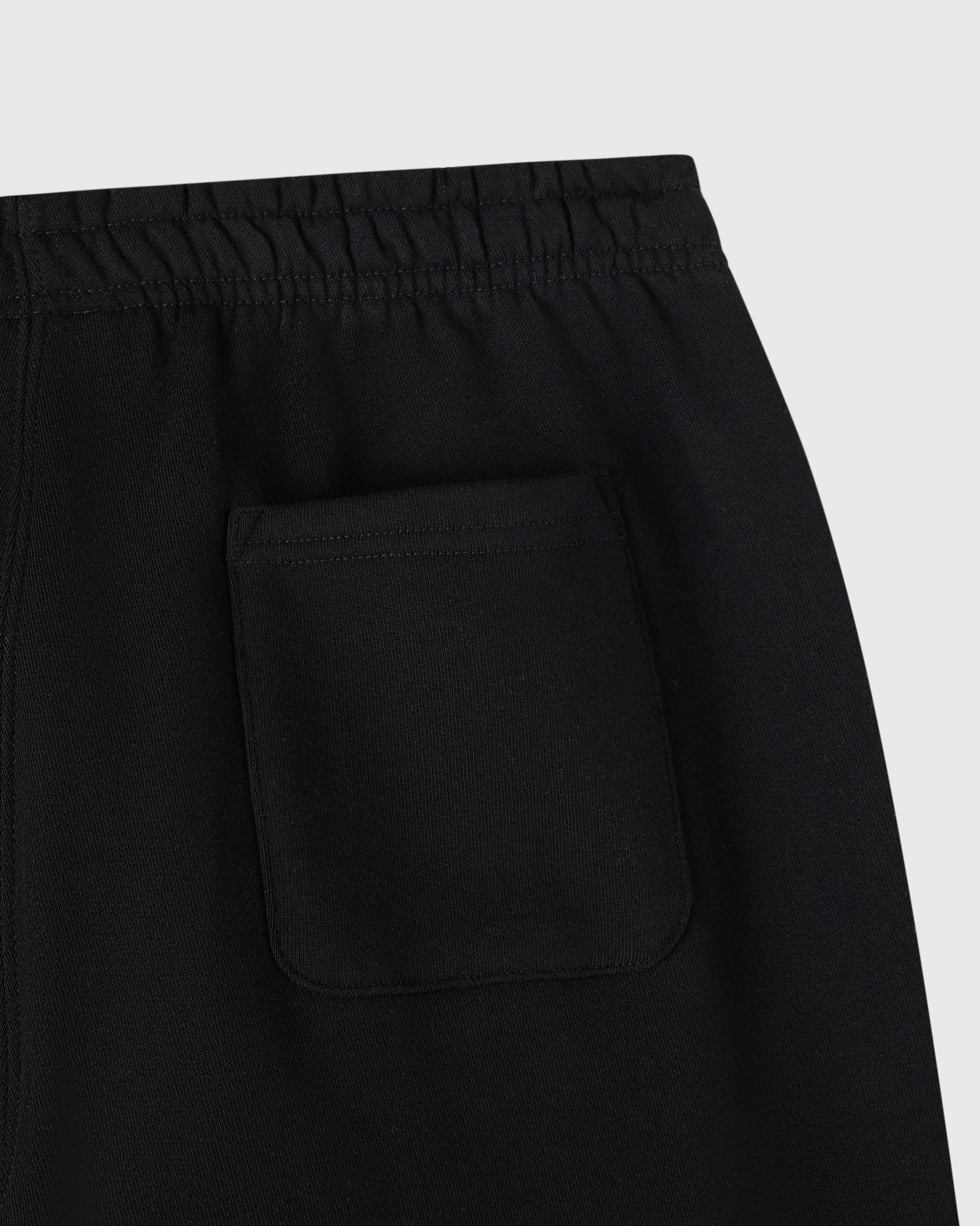 Black sweatpants with elastic waistband and front pocket detail.