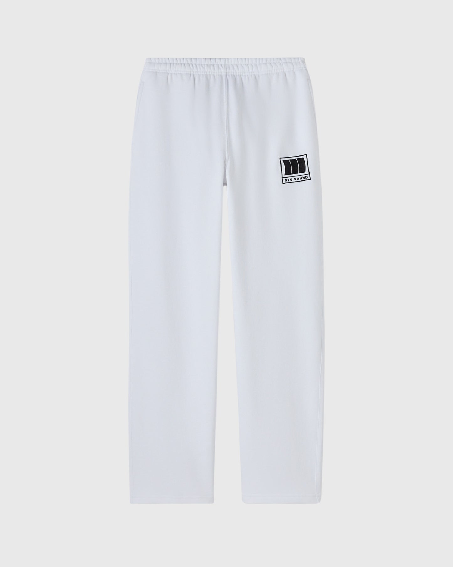 White sweatpants with elasticated waistband and small black OVO Sound logo patch on right thigh.