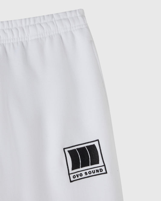 White sweatpant with elastic waistband and black OVO Sound logo patch on thigh.