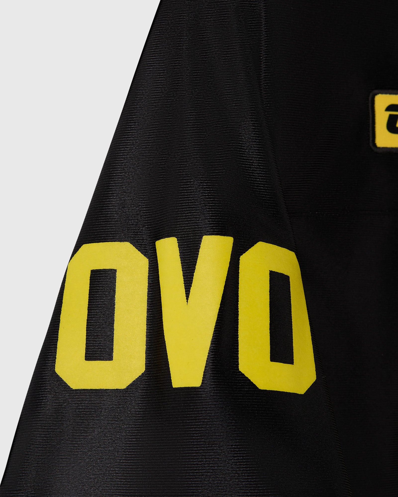 Black football jersey with large yellow block lettering and bat symbol on chest.