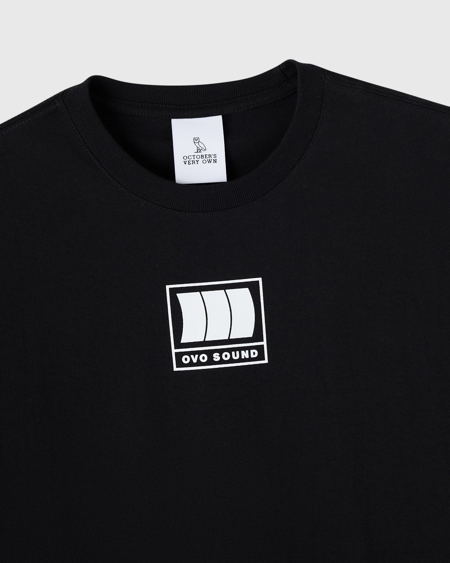 Black crewneck t-shirt with white OVO Sound graphic print on chest and owl brand label at neckline.