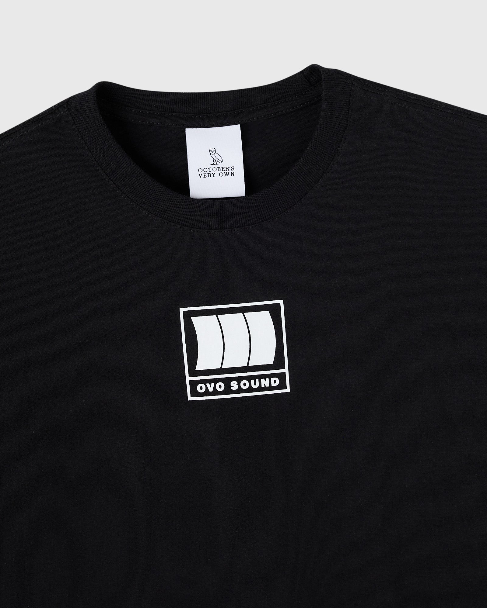 Black crewneck t-shirt with white OVO Sound graphic print on chest and owl brand label at neckline.
