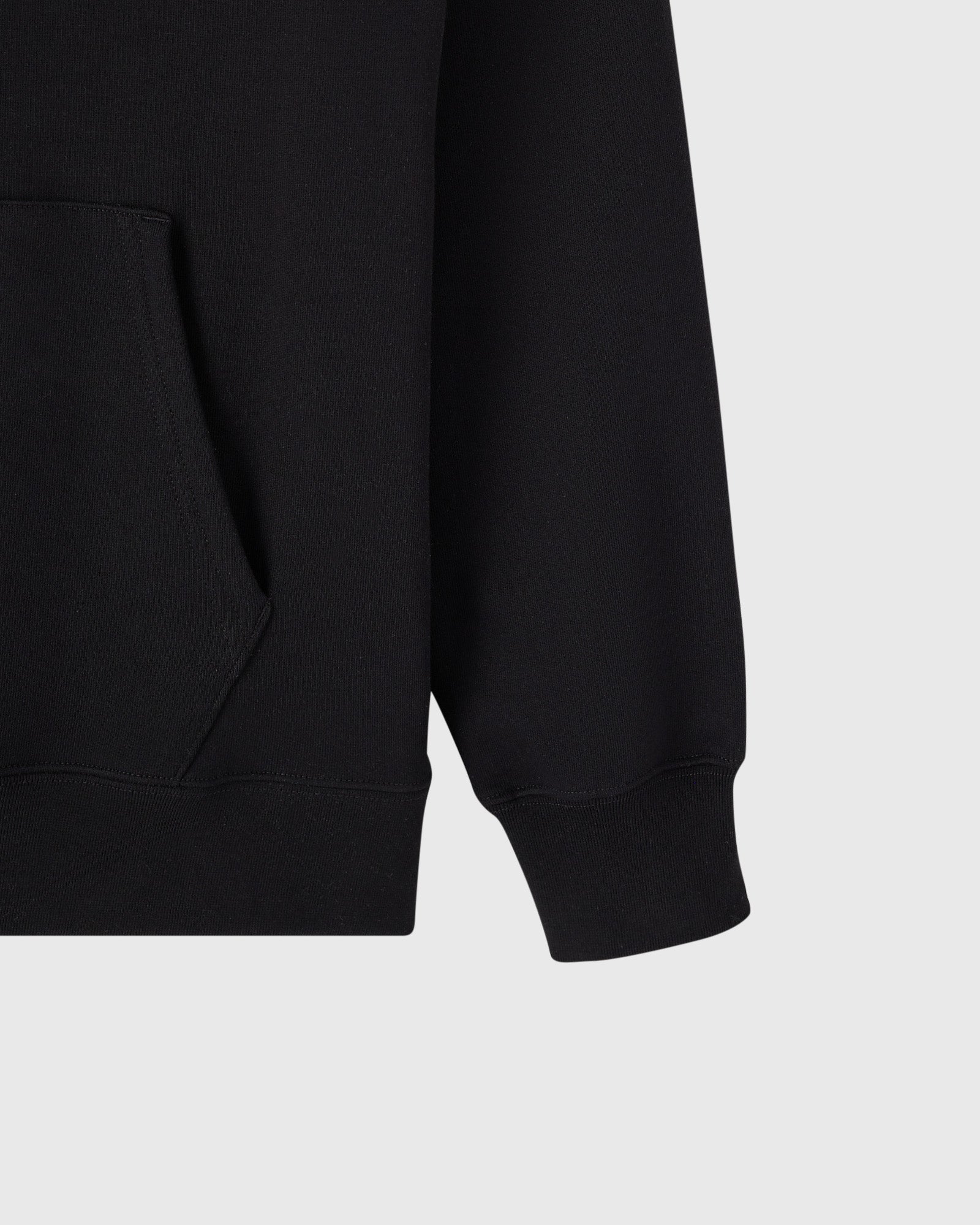 Black hoodie with kangaroo pocket and ribbed cuffs, shown from side detail view.