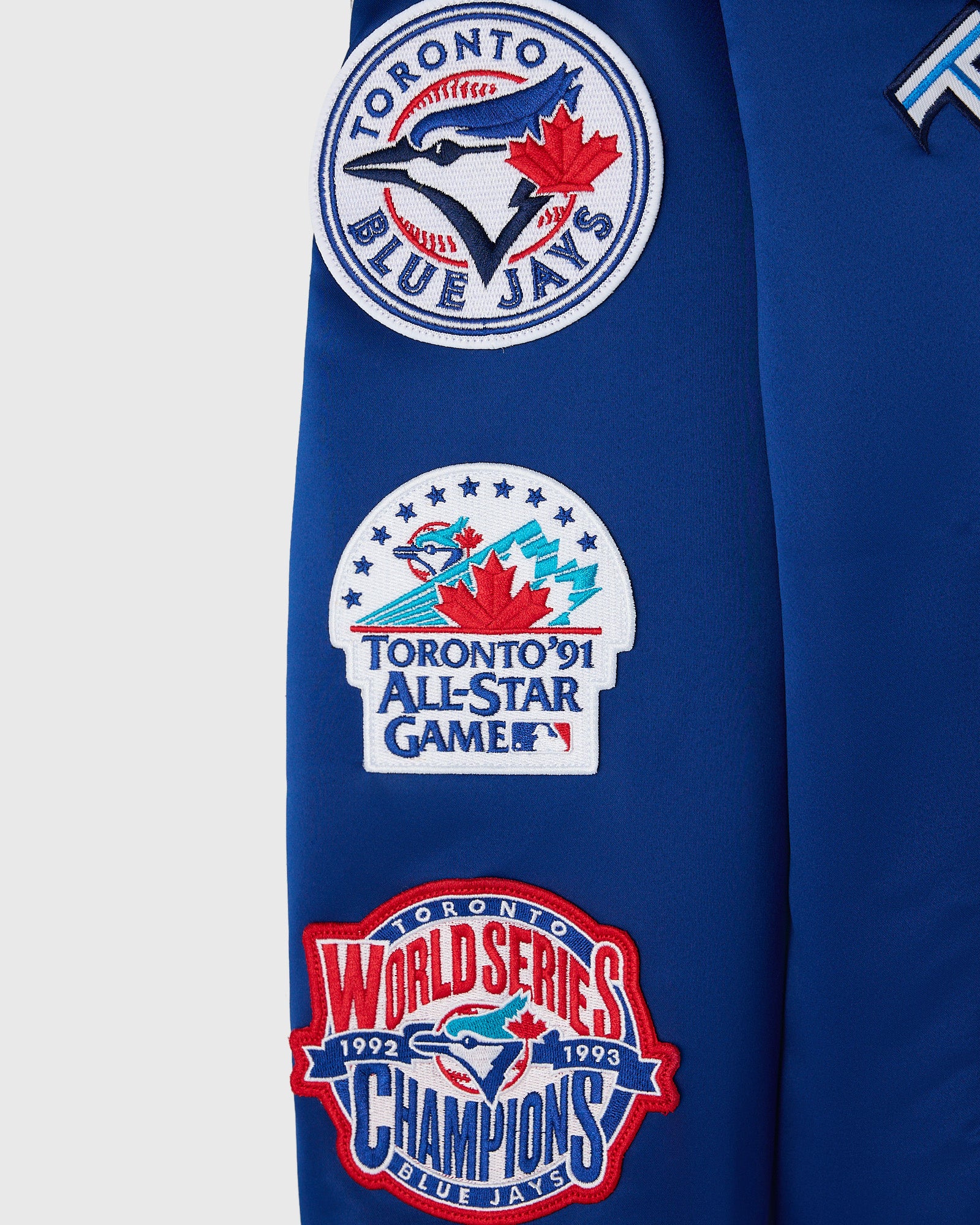 Blue varsity jacket with Toronto Blue Jays circular logo, 1991 All-Star Game patch, and 1992-1993 World Series Champions badg