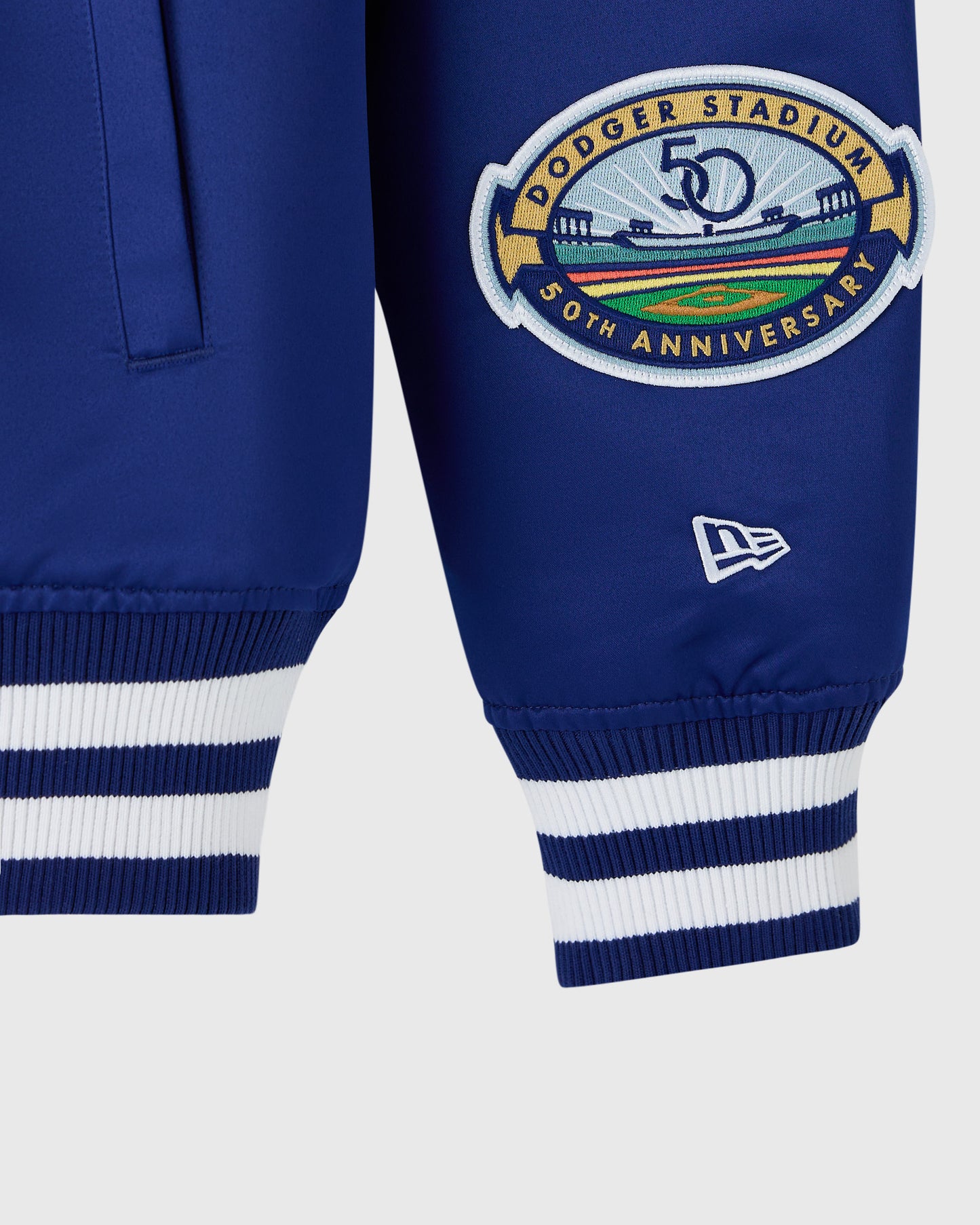 Blue varsity jacket with Dodger Stadium 50th Anniversary embroidered patch and striped ribbed cuffs.
