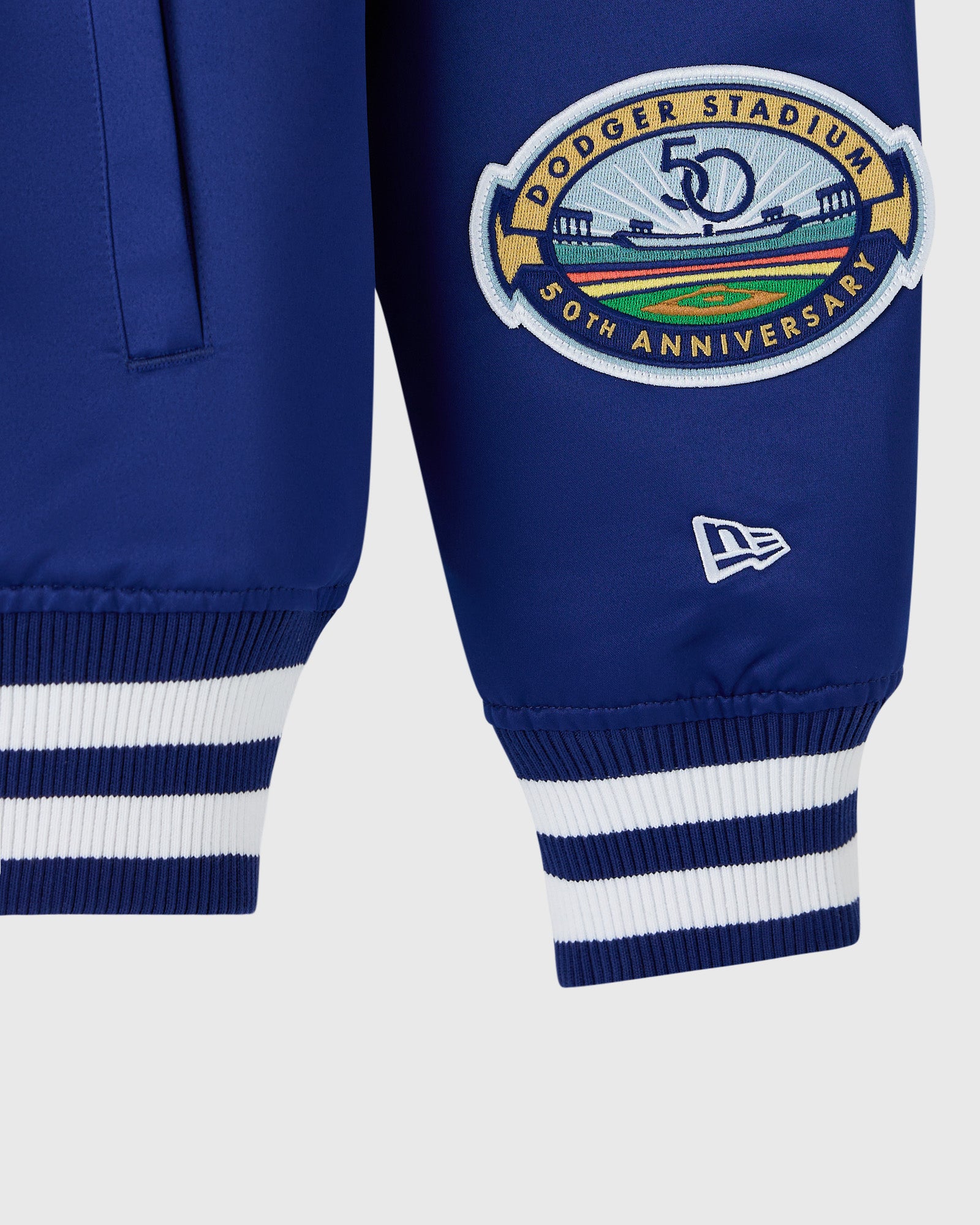 Blue varsity jacket with Dodger Stadium 50th Anniversary embroidered patch and striped ribbed cuffs.