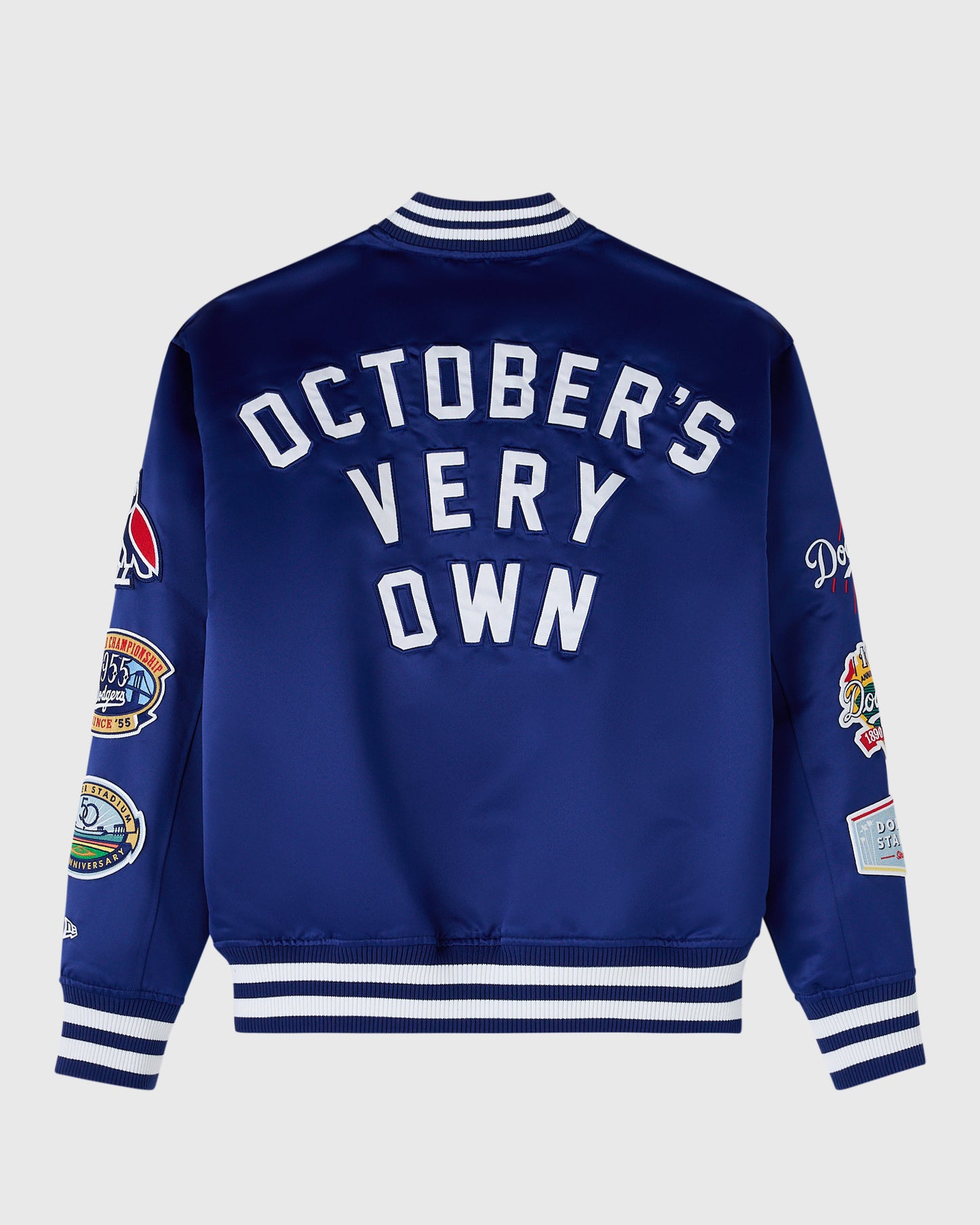 Blue varsity jacket with white "October's Very Own" text on back, striped ribbed collar and cuffs, and embroidered patches on