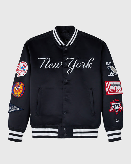 Navy varsity jacket with "New York" script, Yankees patches on sleeves, striped ribbed collar and cuffs, button front closure