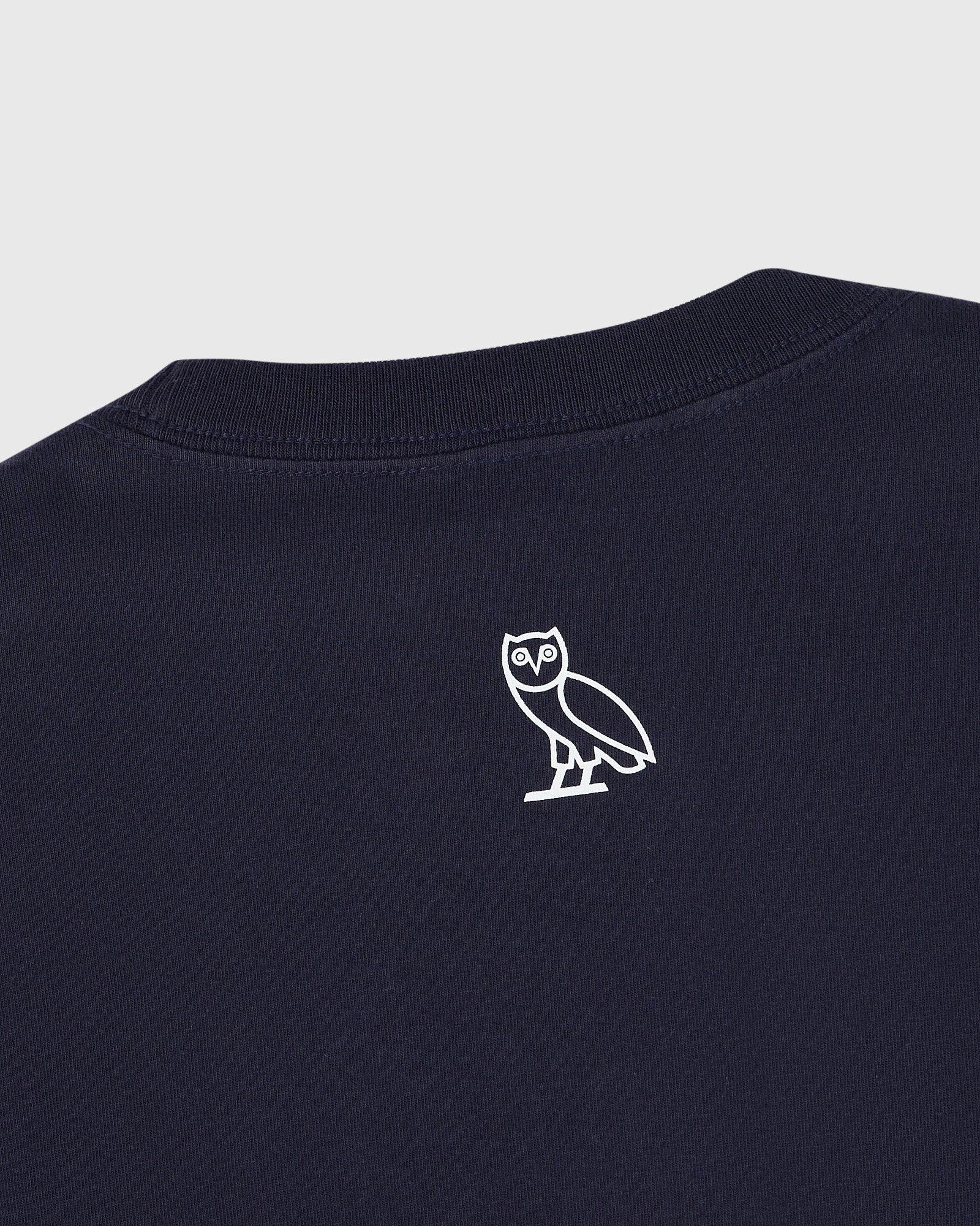 Navy blue t-shirt with small white owl outline graphic on chest.