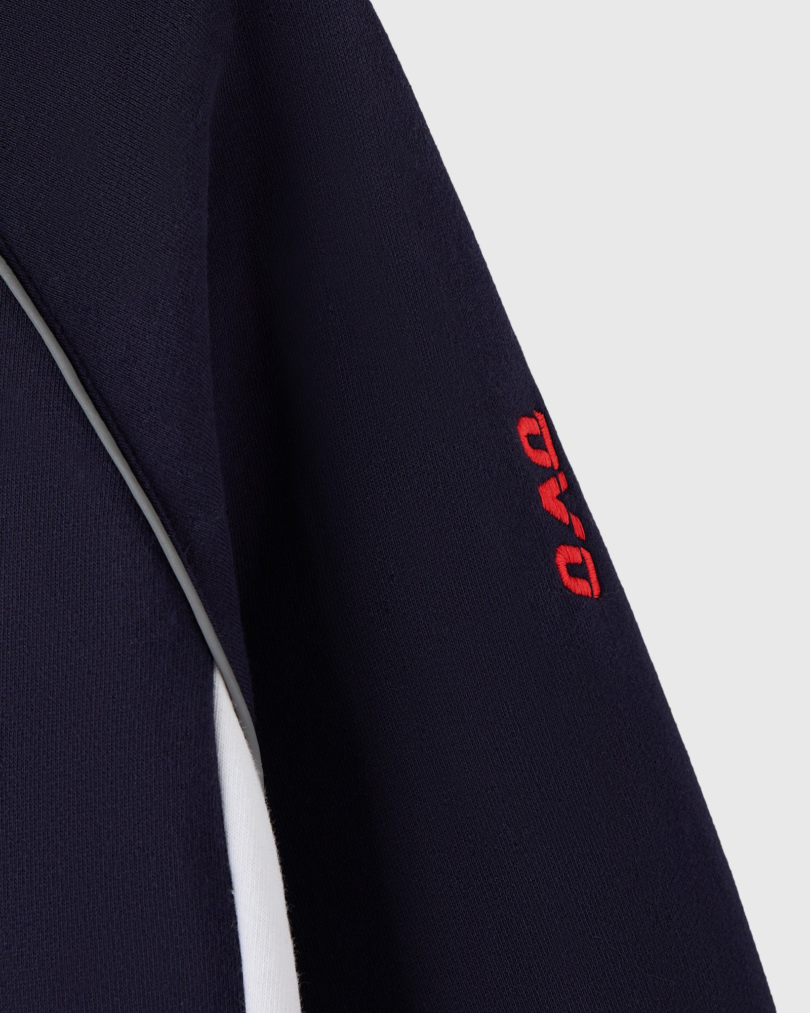 Navy hoodie with white side stripe and red logo embroidery on sleeve.