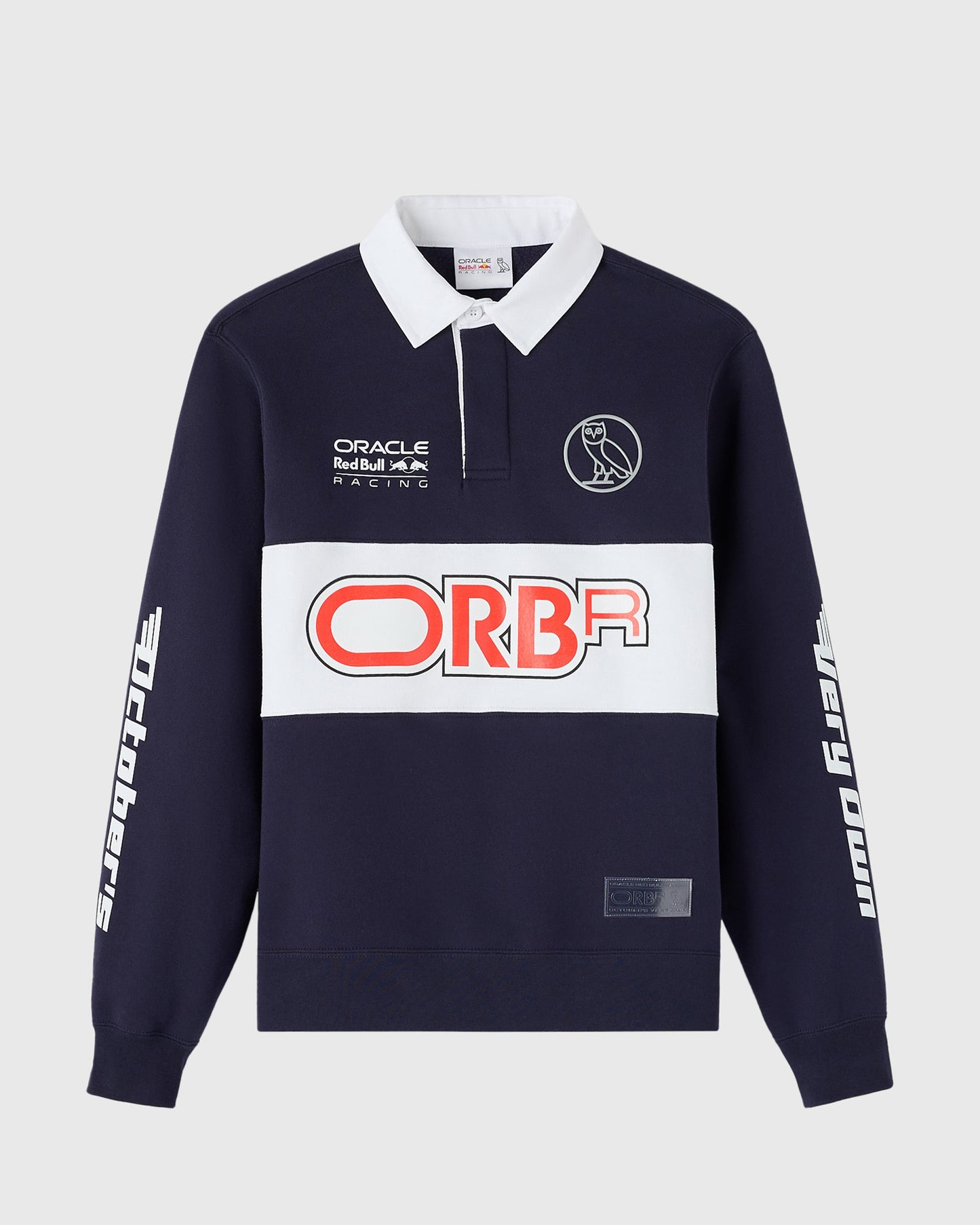 Navy fleece rugby shirt with white collar, Oracle Red Bull Racing and ORBA branding, owl logo, and white sleeve graphics.