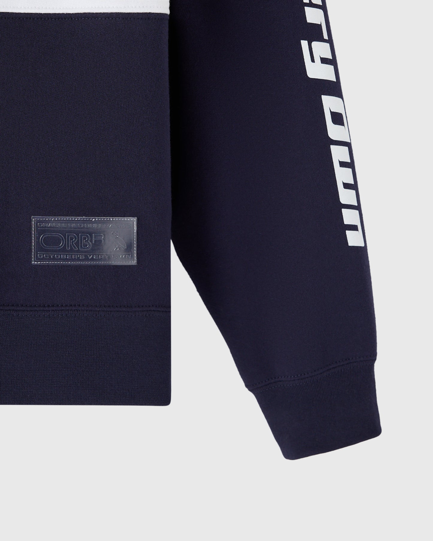 Navy fleece rugby with white text stripe on sleeve and embroidered patch on chest.
