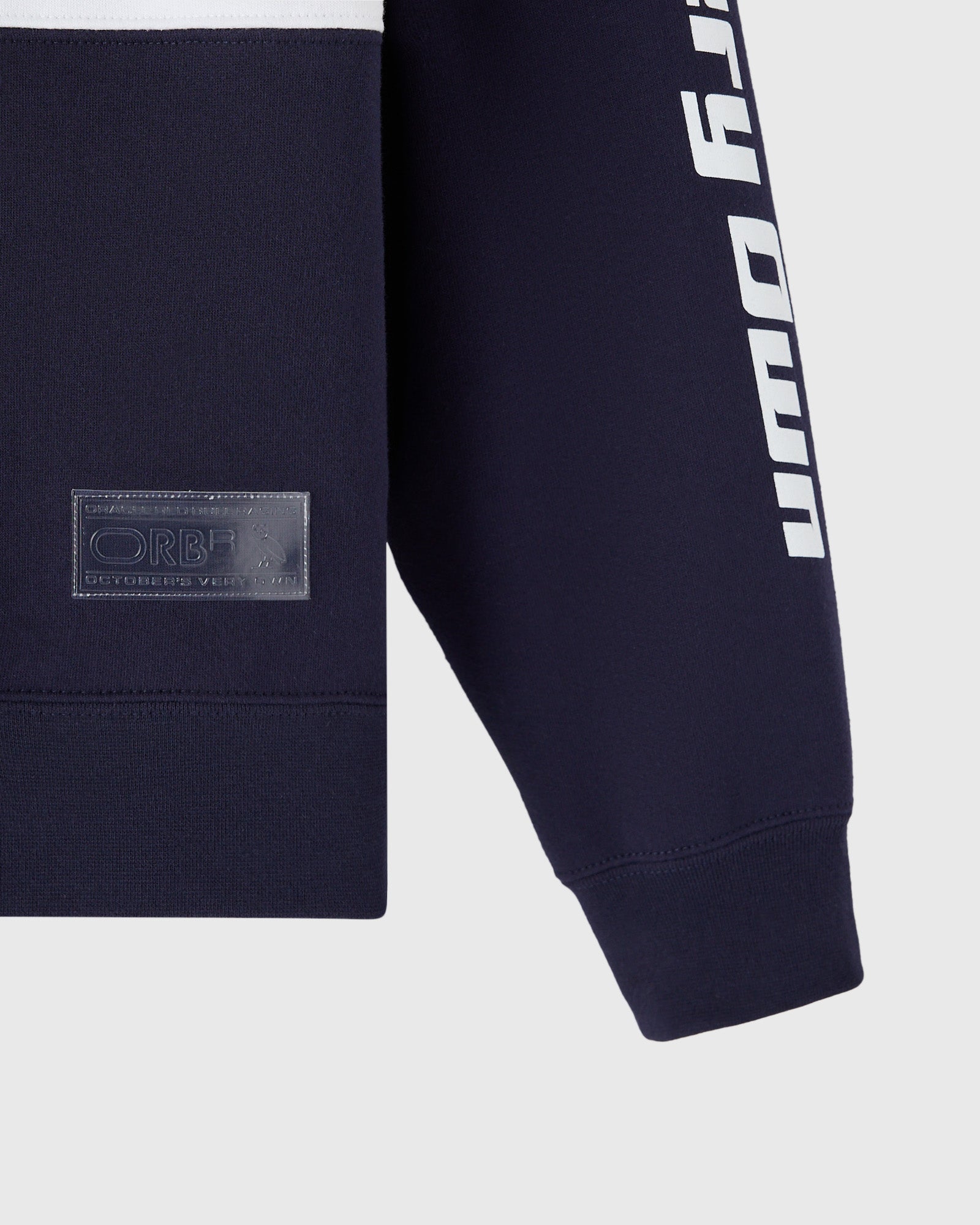 Navy fleece rugby with white text stripe on sleeve and embroidered patch on chest.