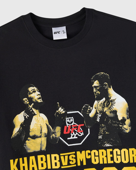 Black t-shirt with UFC logo and gold-toned graphic of two fighters with "KHABIB VS MCGREGOR" text at bottom.
