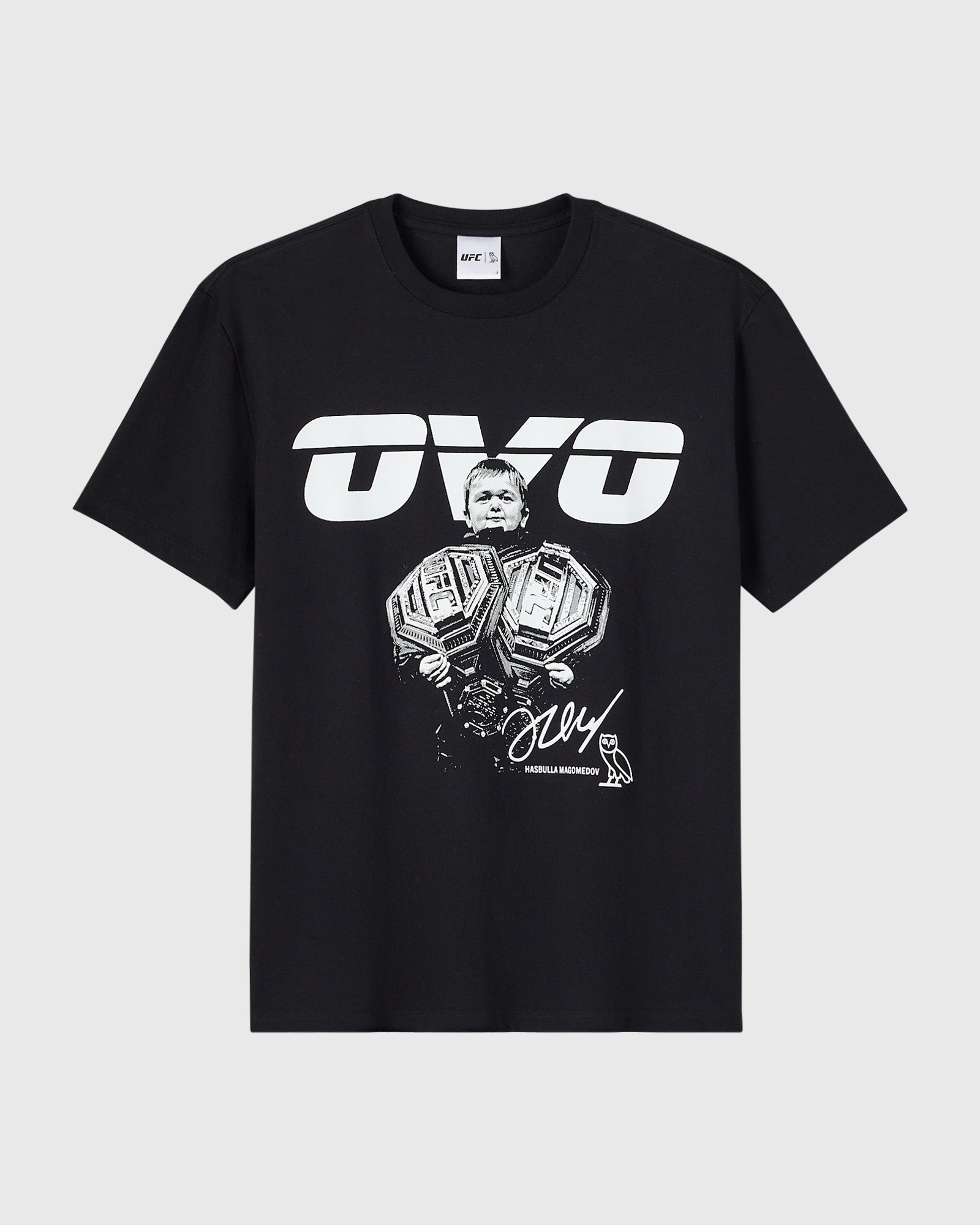 Black t-shirt with white UFC logo and illustration of a Hasbulla holding two championship belts with signature text.