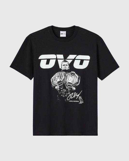 Black t-shirt with white UFC logo and illustration of a Hasbulla holding two championship belts with signature text.
