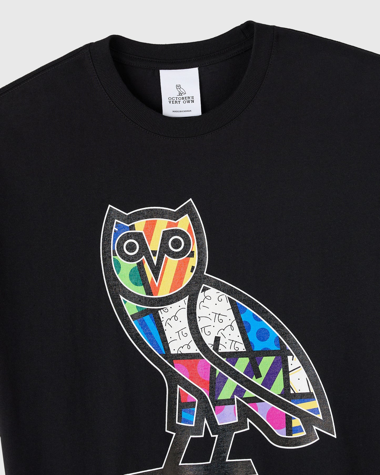 Black crewneck t-shirt with colorful geometric owl graphic on chest featuring multicolored pattern sections.