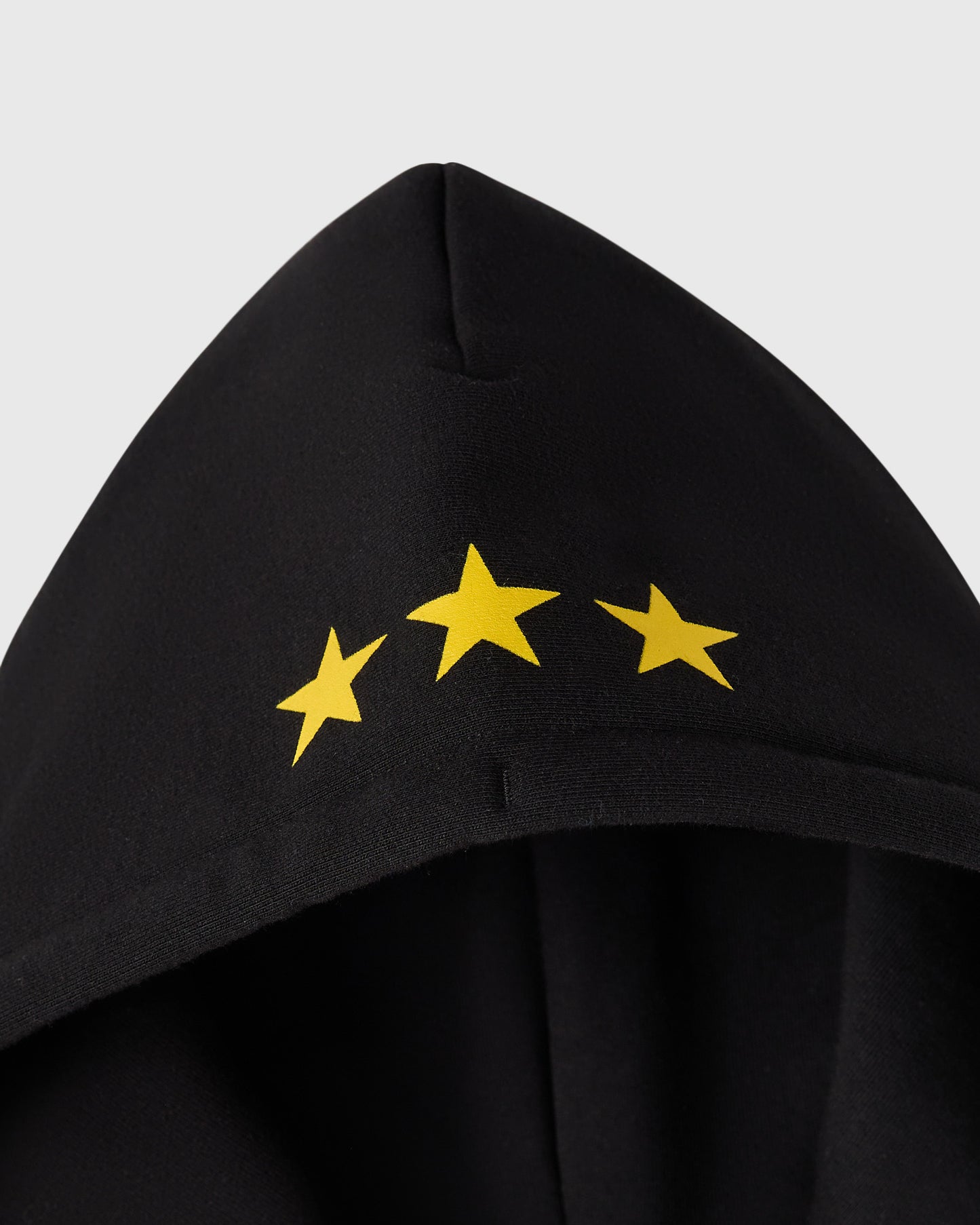 Black full-zip hoodie with three yellow stars printed on the chest.