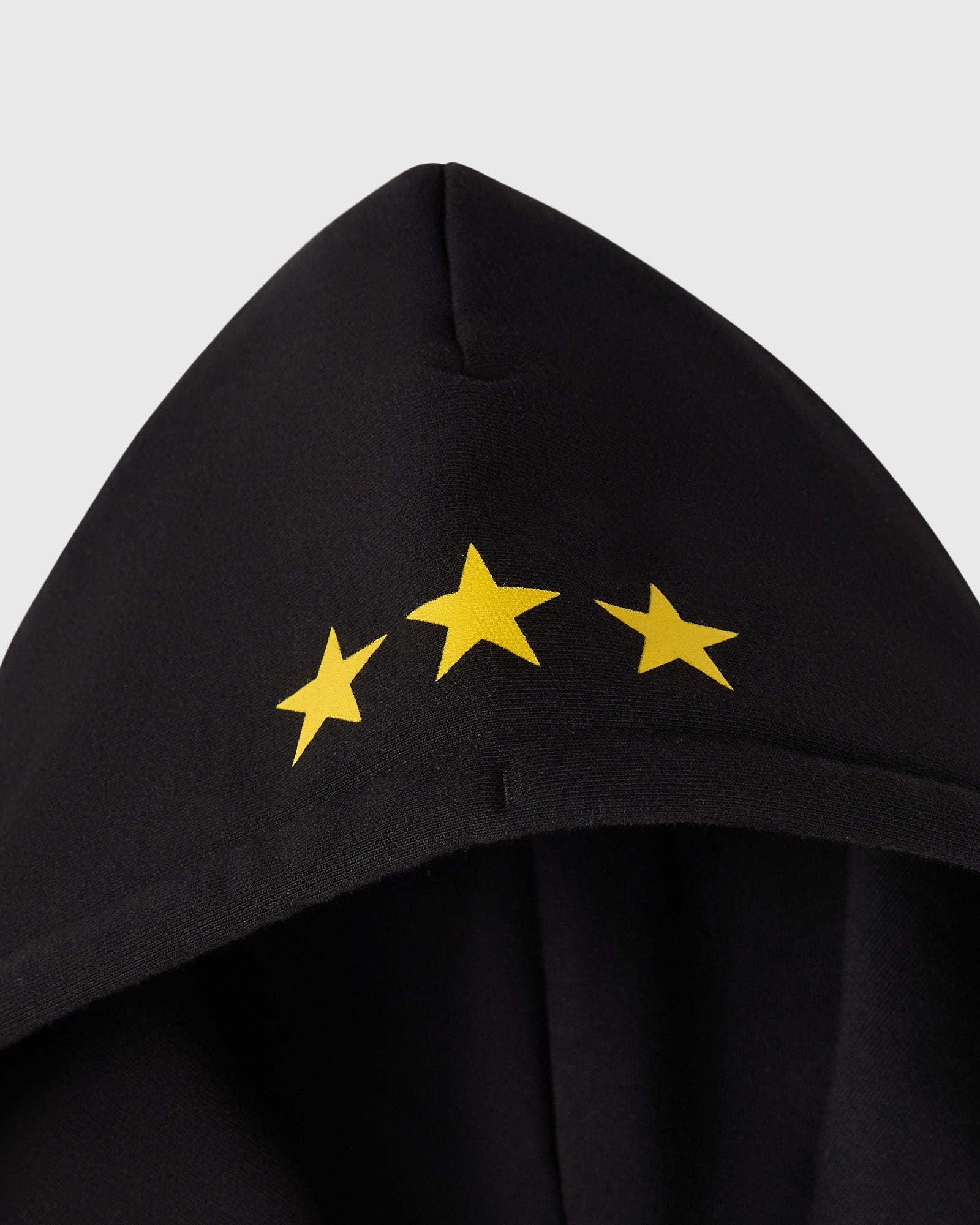 Black full-zip hoodie with three yellow stars printed on the chest.