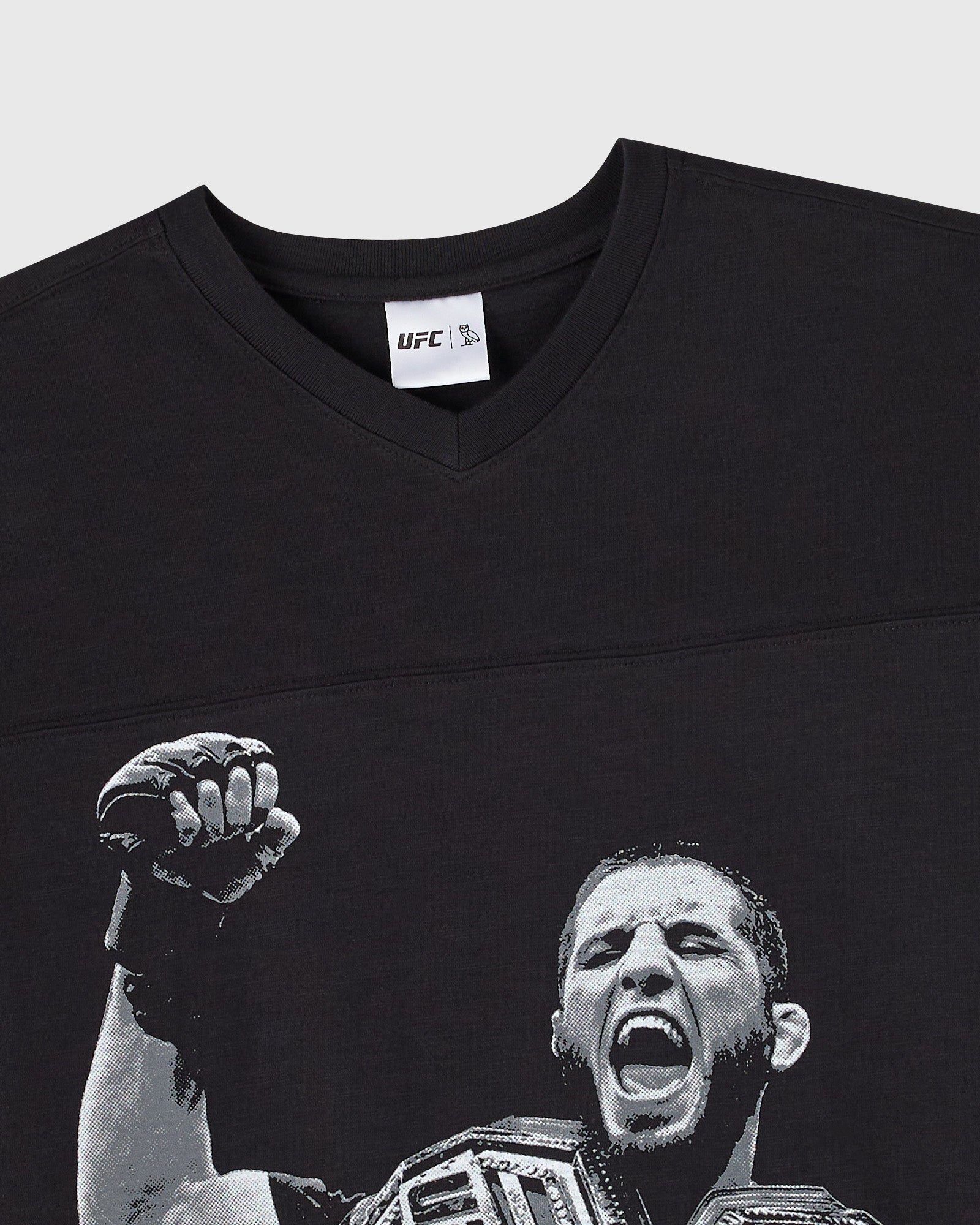 Black t-shirt with UFC logo on neck label and fighter portrait graphic with raised fist on front.