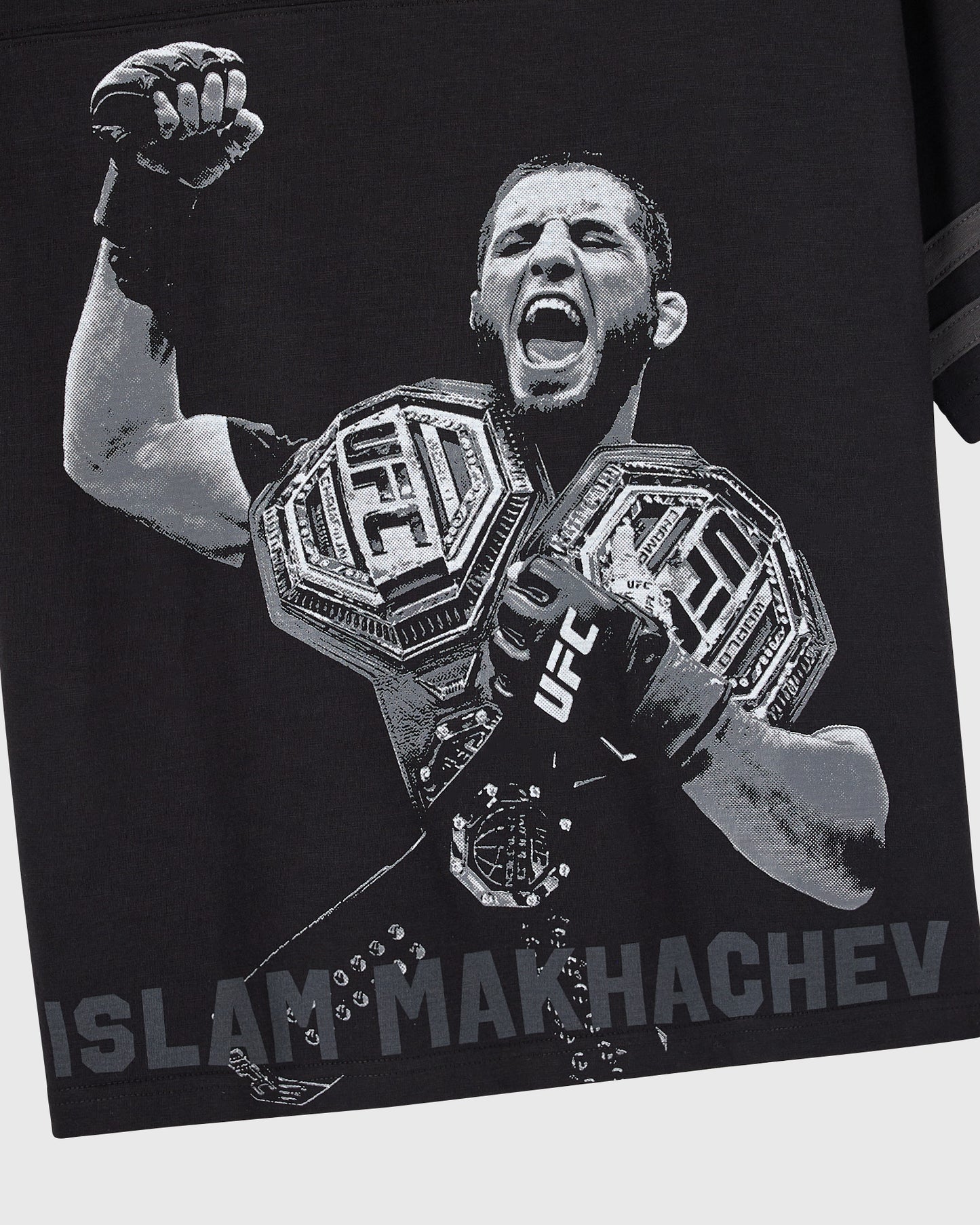 Black tee with white graphic of fighter holding UFC championship belts and raising fist, "Islam Makhachev" text at bottom.