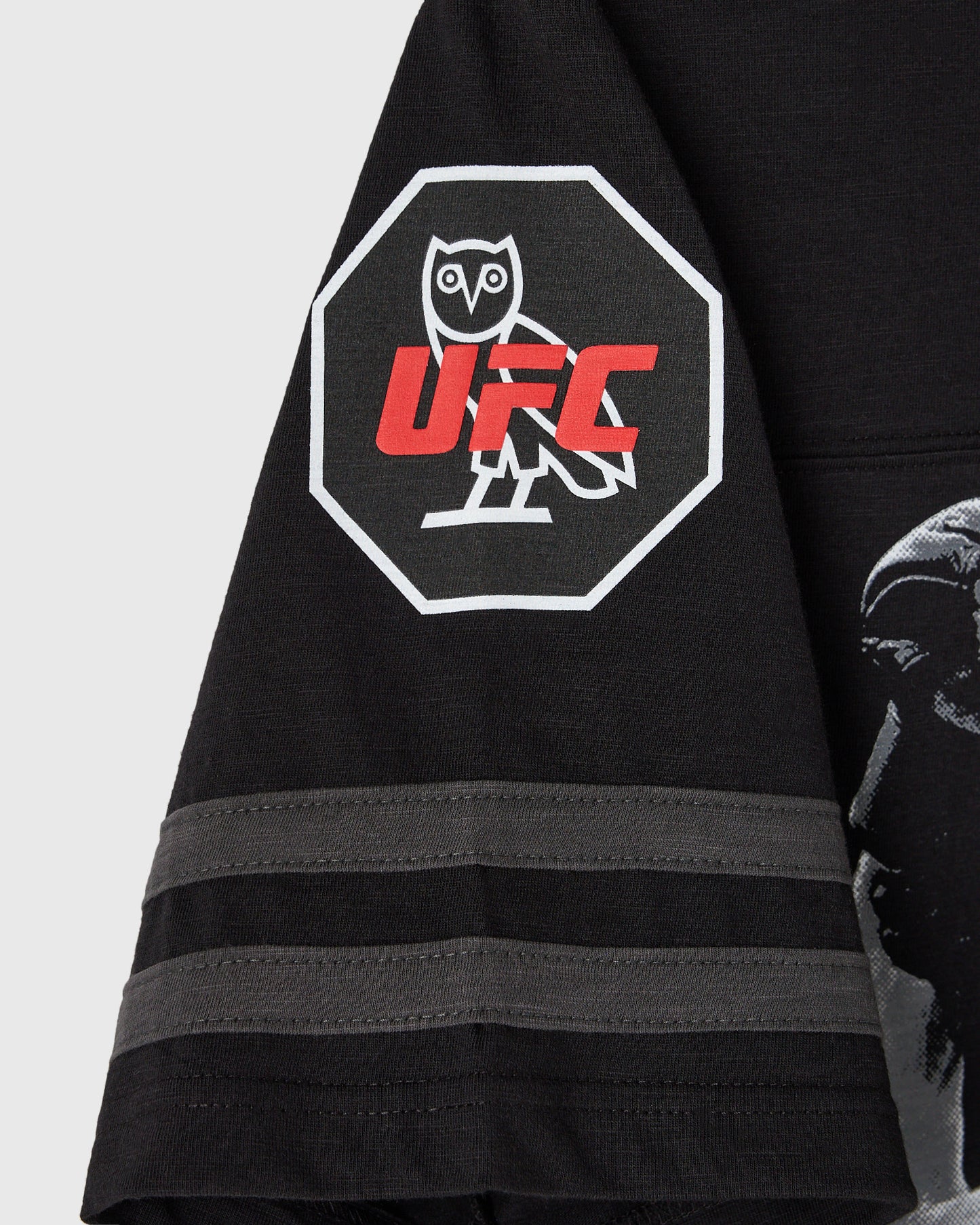 Black football tee with white-bordered octagon graphic featuring owl and red UFC text on chest.
