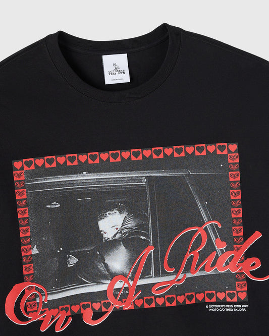Black long-sleeve tee with red heart border and black-and-white photo graphic with red script text on front.