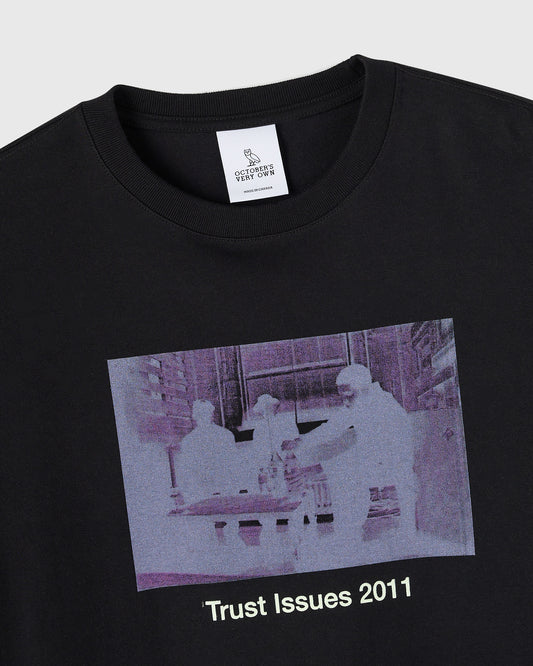 Black crewneck t-shirt with purple-tinted surveillance camera image and "Trust Issues 2011" text printed on chest.