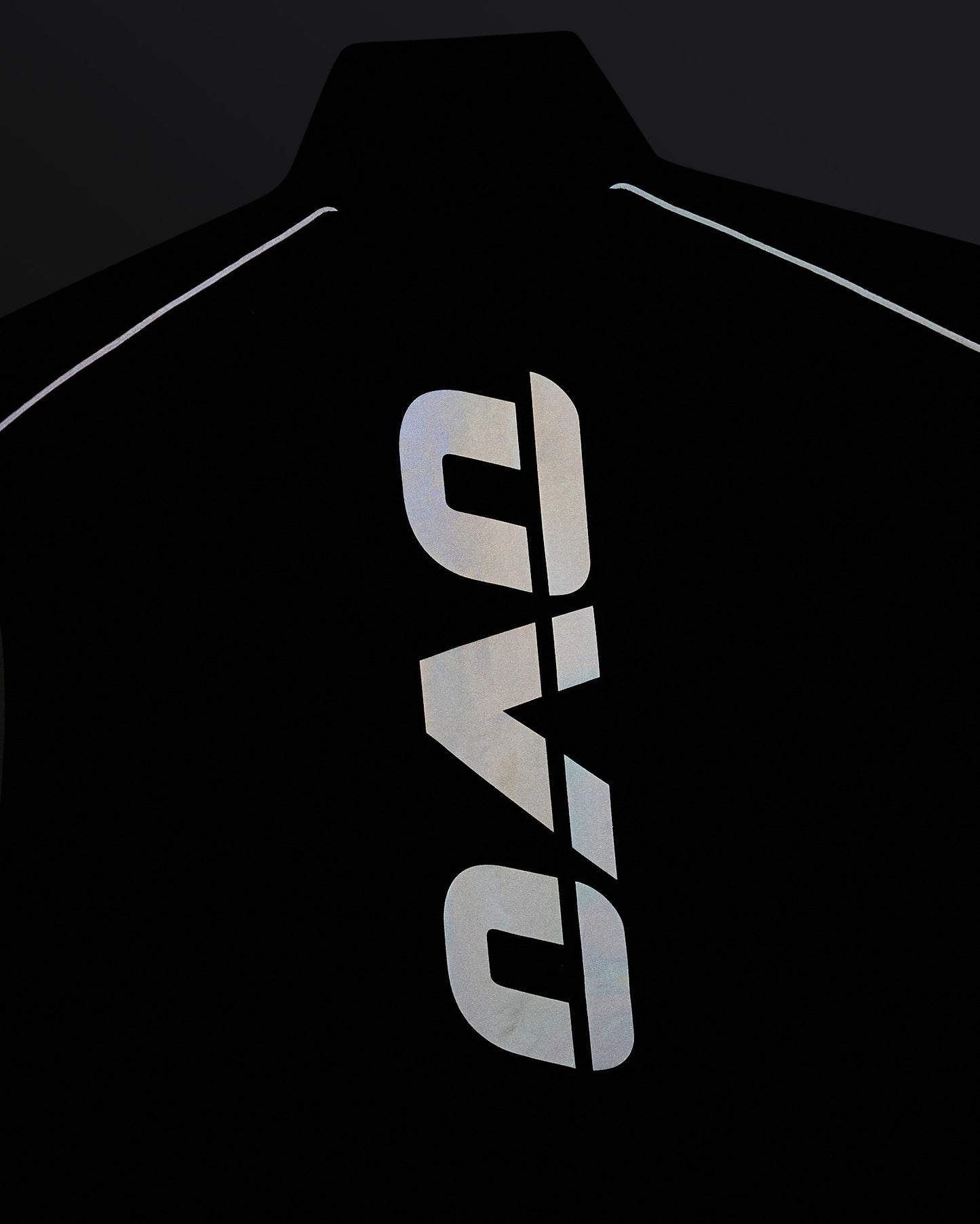 Navy nylon vest with reflective vertical logo print down the center and reflective piping along shoulders.