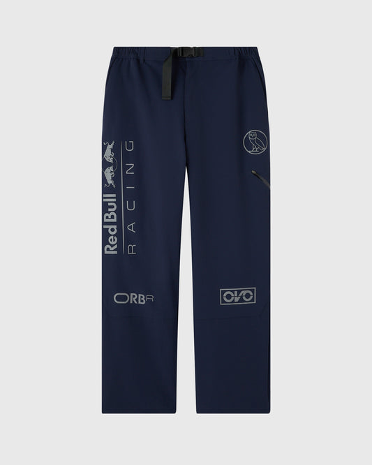 Navy nylon pants with reflective Red Bull Racing and sponsor logos printed across legs and waistband belt.