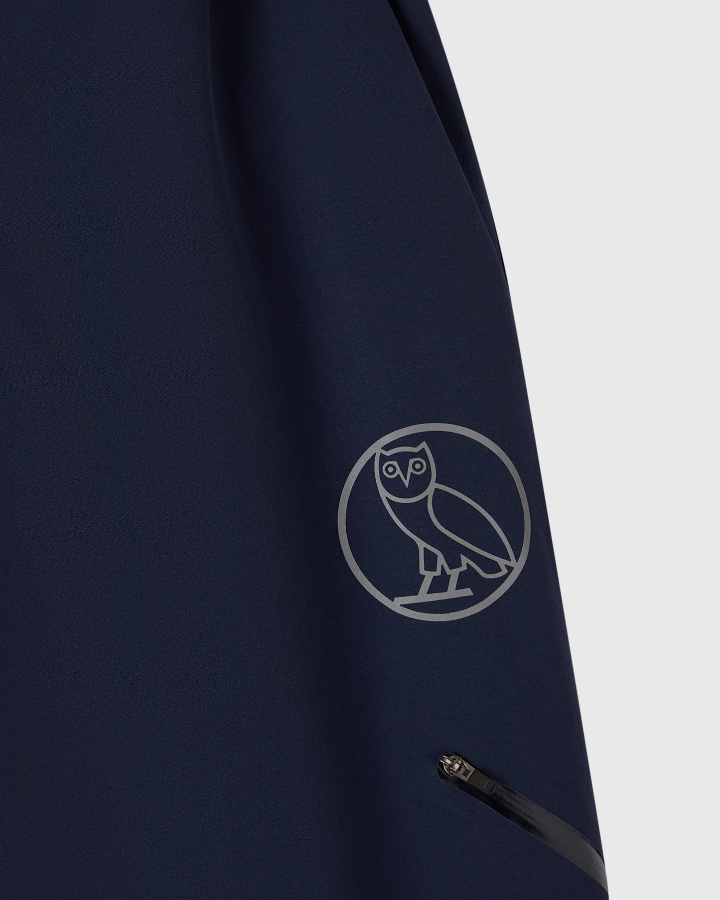 Navy nylon pant with reflective owl logo print on thigh and side pocket detail.