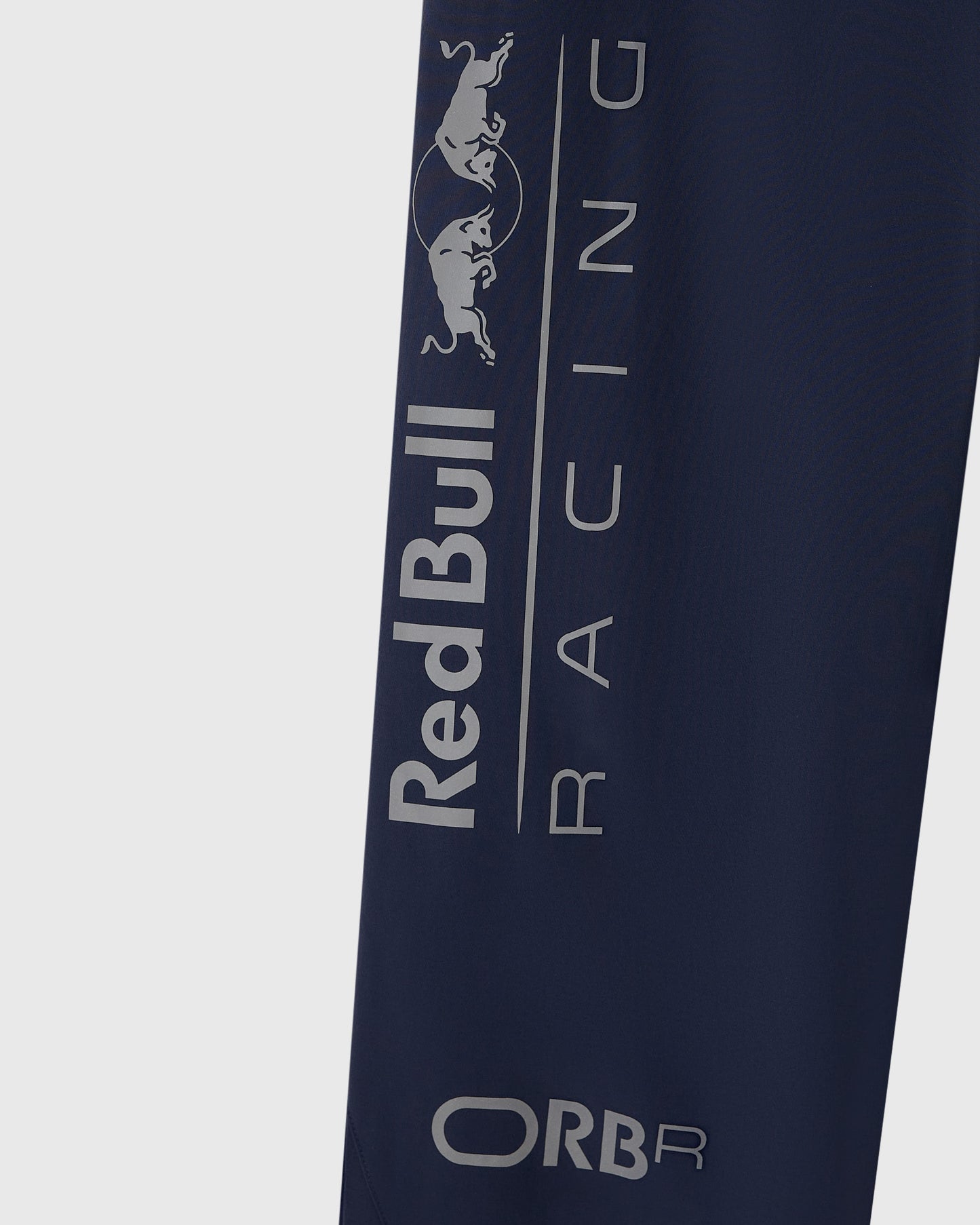 Navy nylon pant leg with reflective Red Bull Racing logo and bull graphic print down the side.