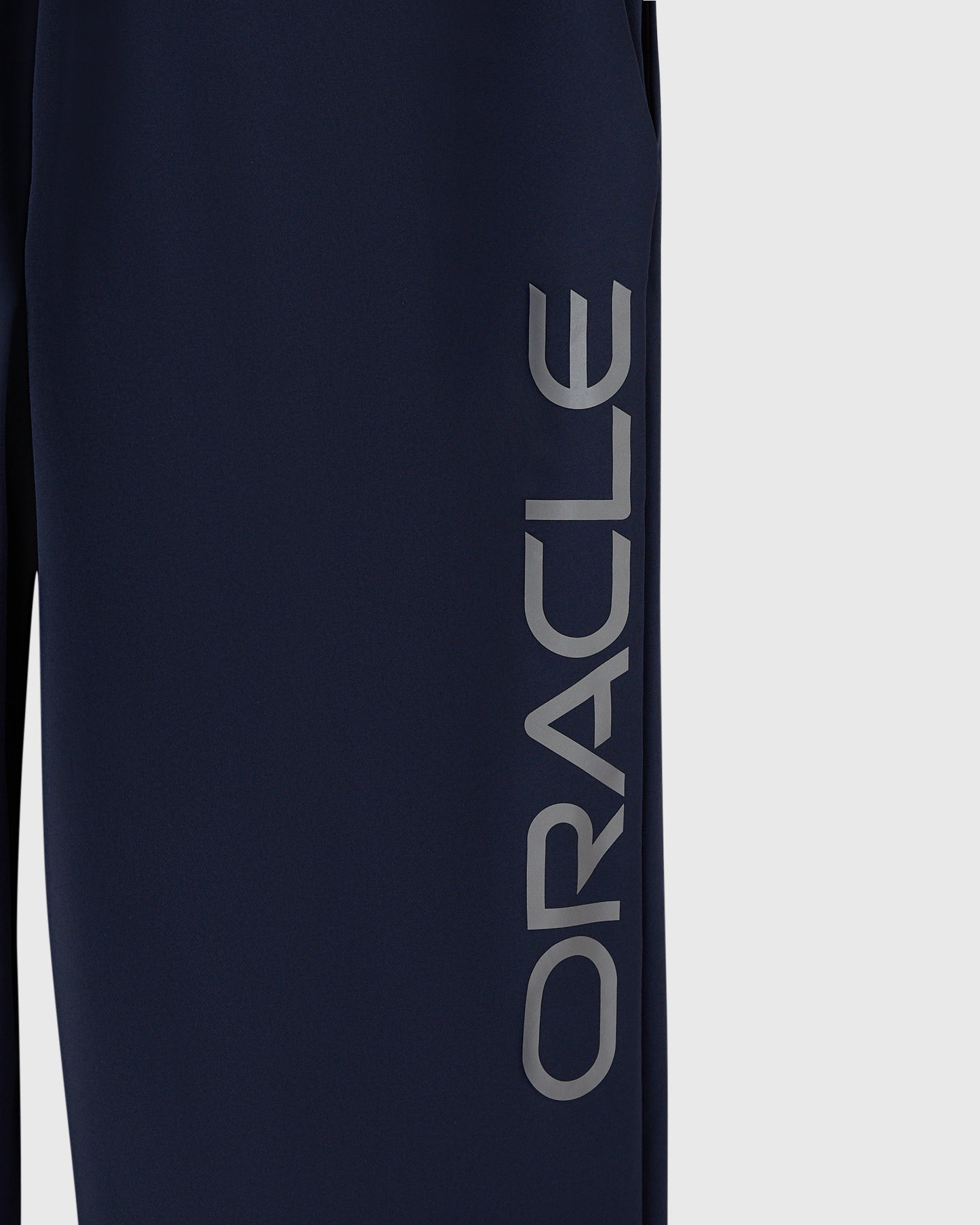 Navy nylon pant with reflective "Oracle" text printed down the leg.