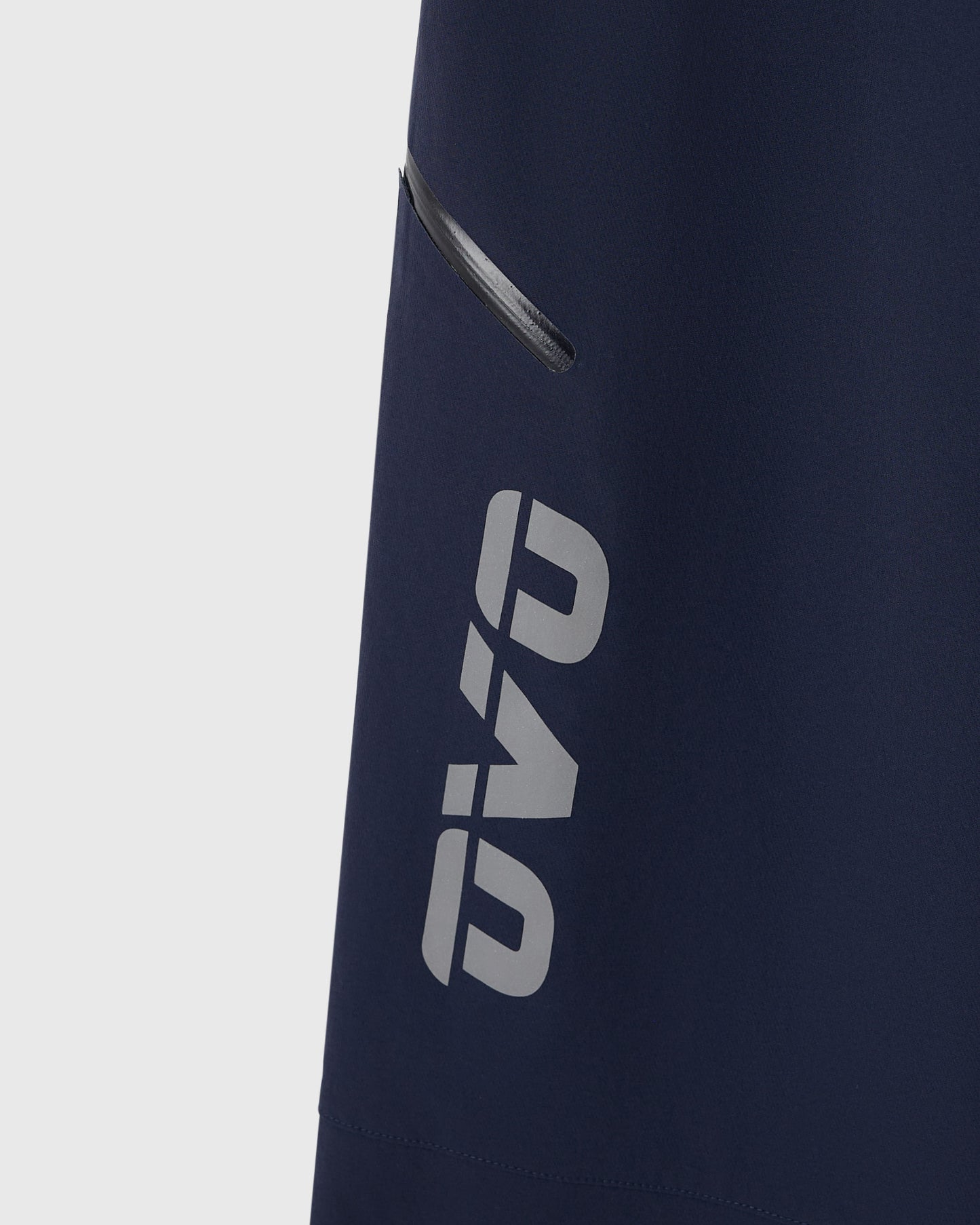 Navy nylon pants with reflective "RB" logo print and side zip pocket detail.