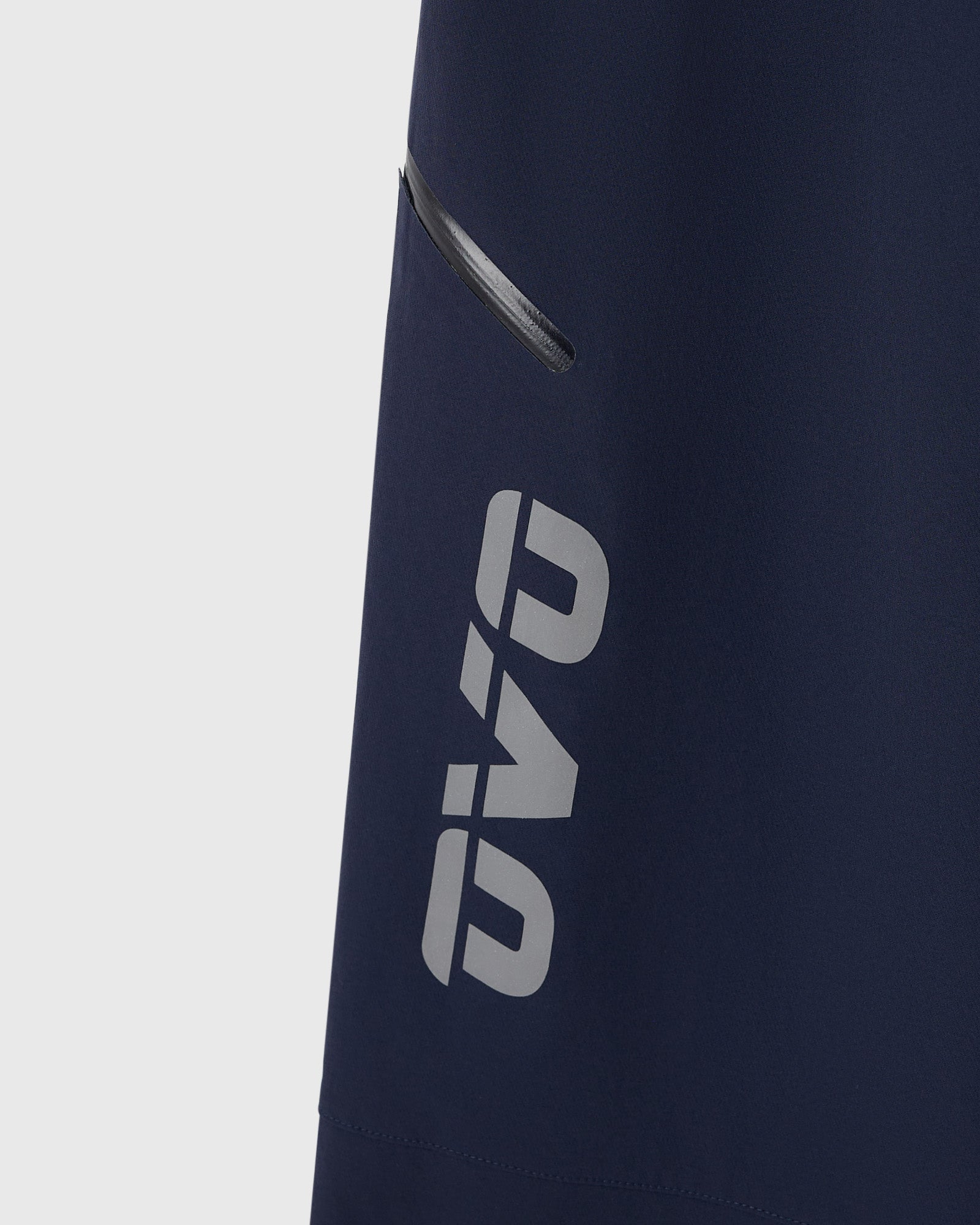 Navy nylon pants with reflective "RB" logo print and side zip pocket detail.