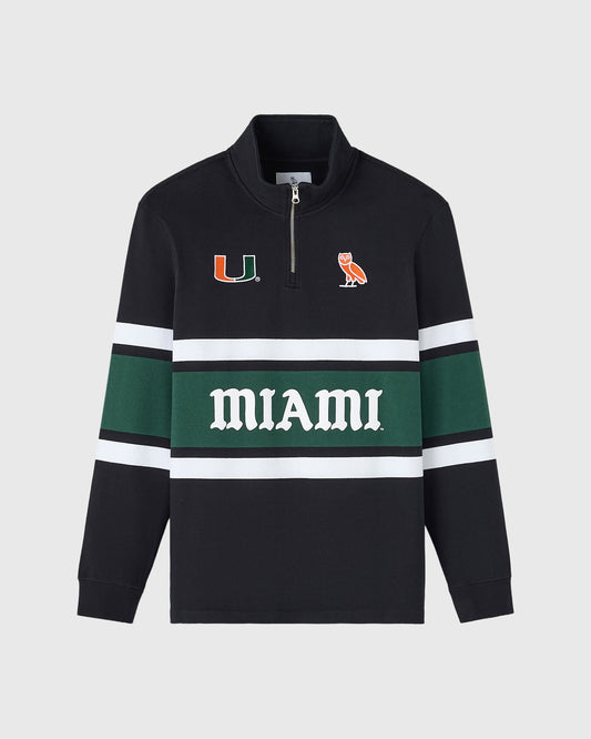 Black rugby pullover with quarter-zip, featuring University of Miami "U" logo and owl mascot, green stripe with "MIAMI" text,