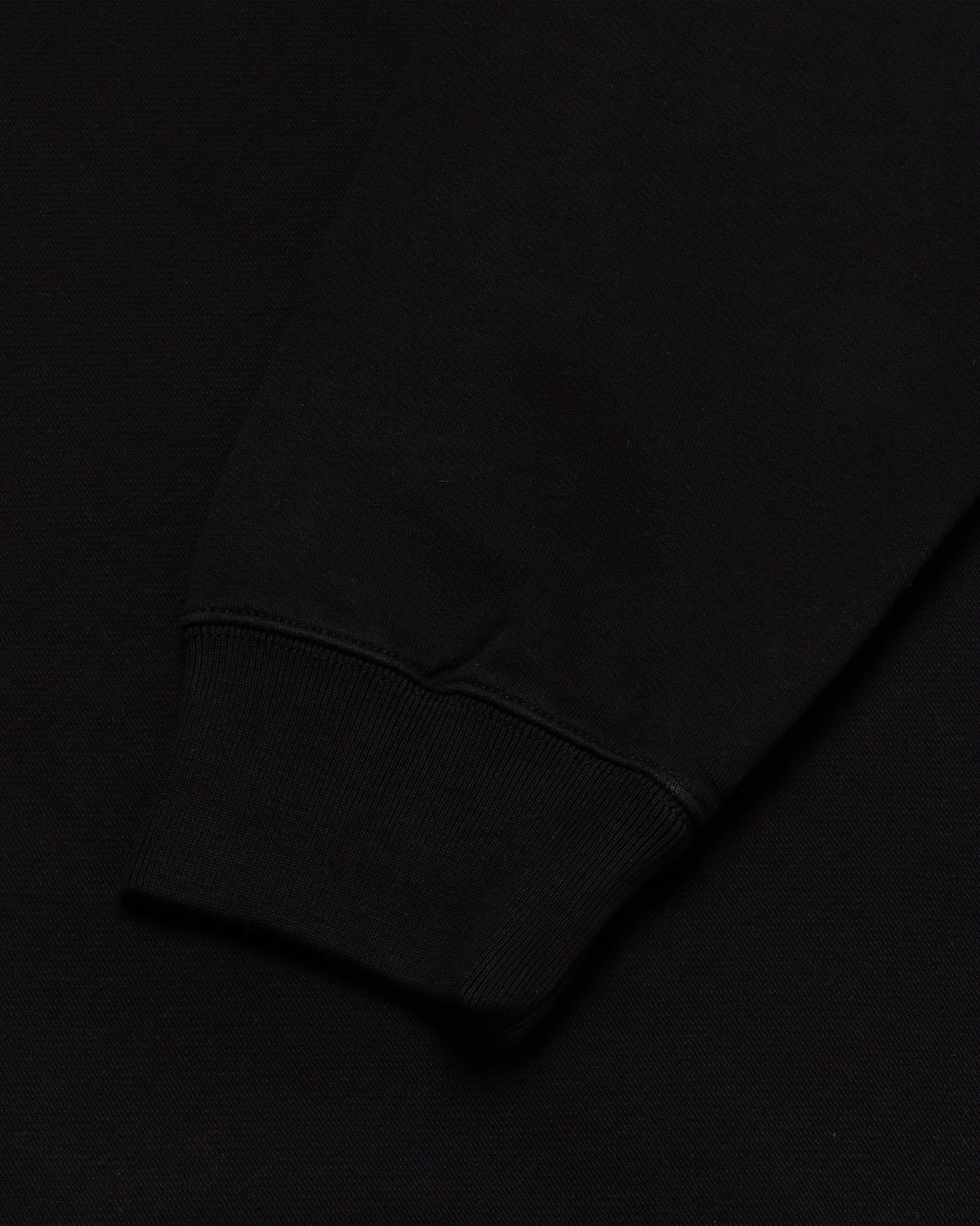 Black crewneck sweatshirt with ribbed cuff detail visible at sleeve.