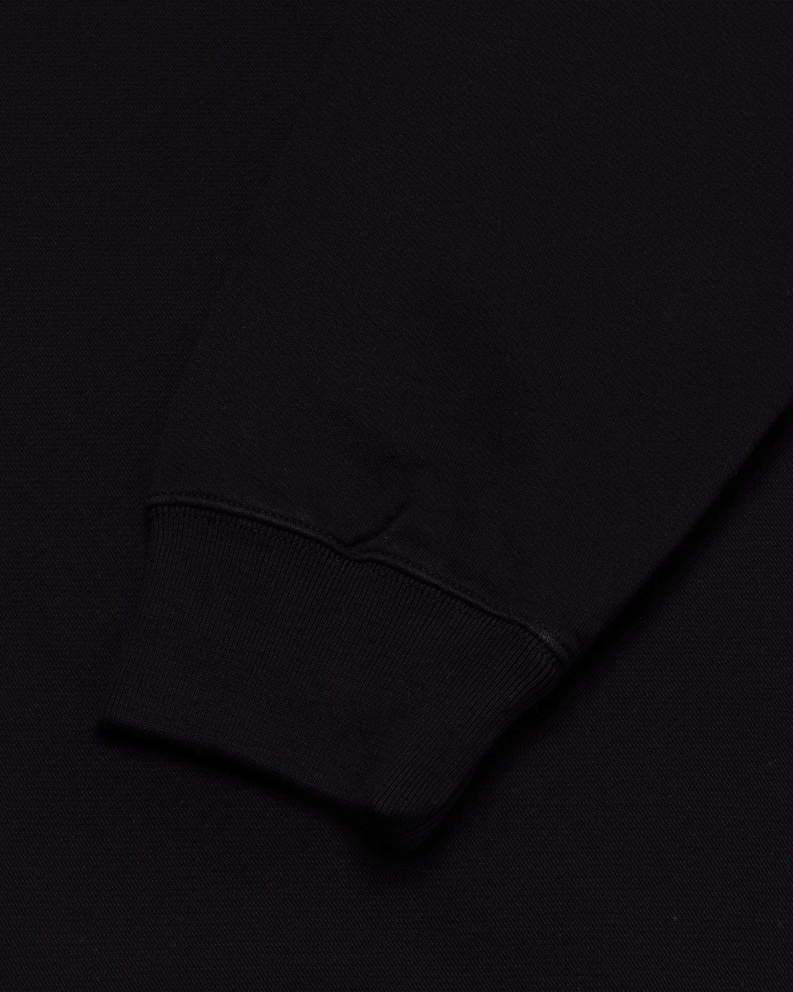Black crewneck sweatshirt with ribbed cuff detail visible at sleeve.