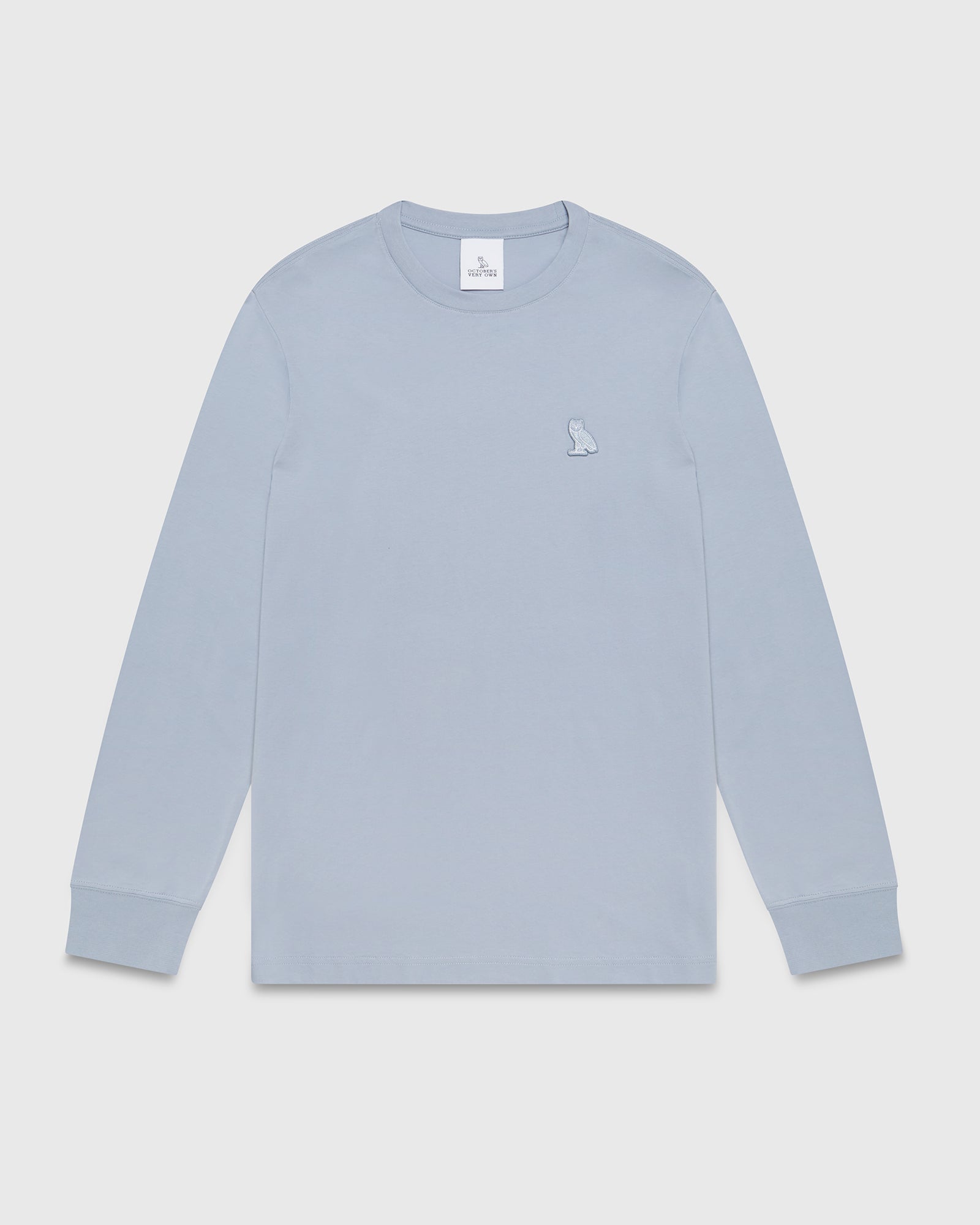 Light blue long-sleeve t-shirt with small owl embroidery on chest and ribbed cuffs.