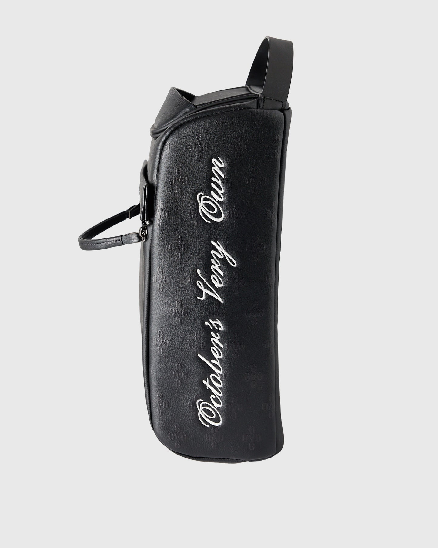 Black cylindrical golf bag with white monogram text and single shoulder strap.