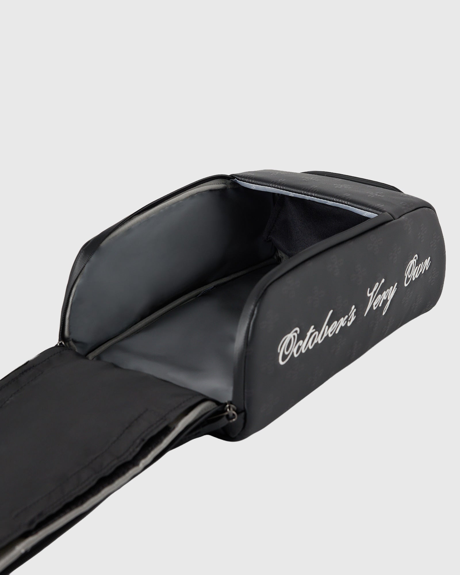 Black golf shag bag with white monogram text on side, open top showing dark interior.