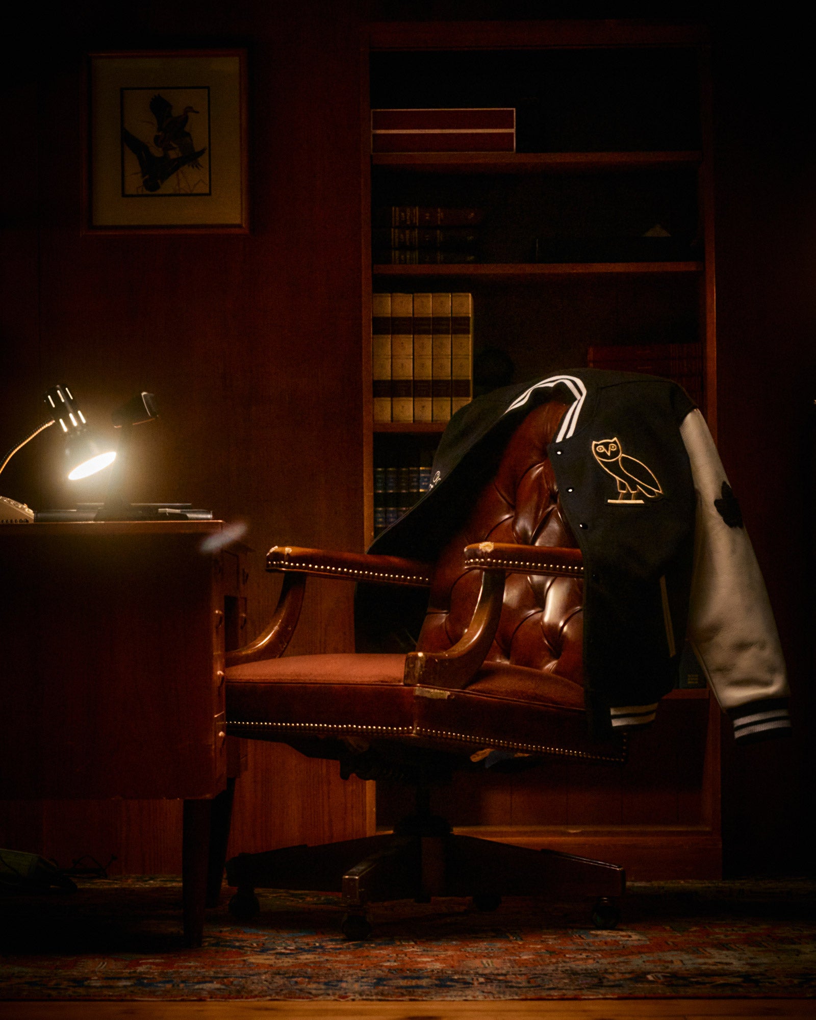 October's Very Own Collegiate Collection varsity draped over chair inside office.