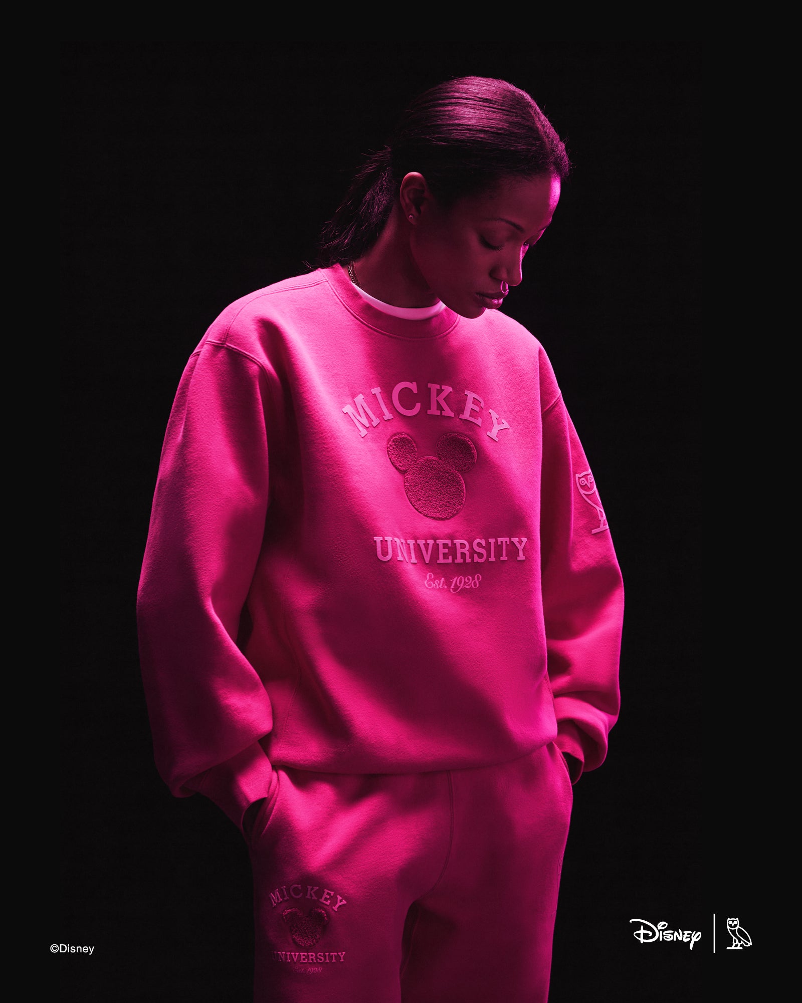 Person wearing pink October's Very Own x Disney outfits with a dark background