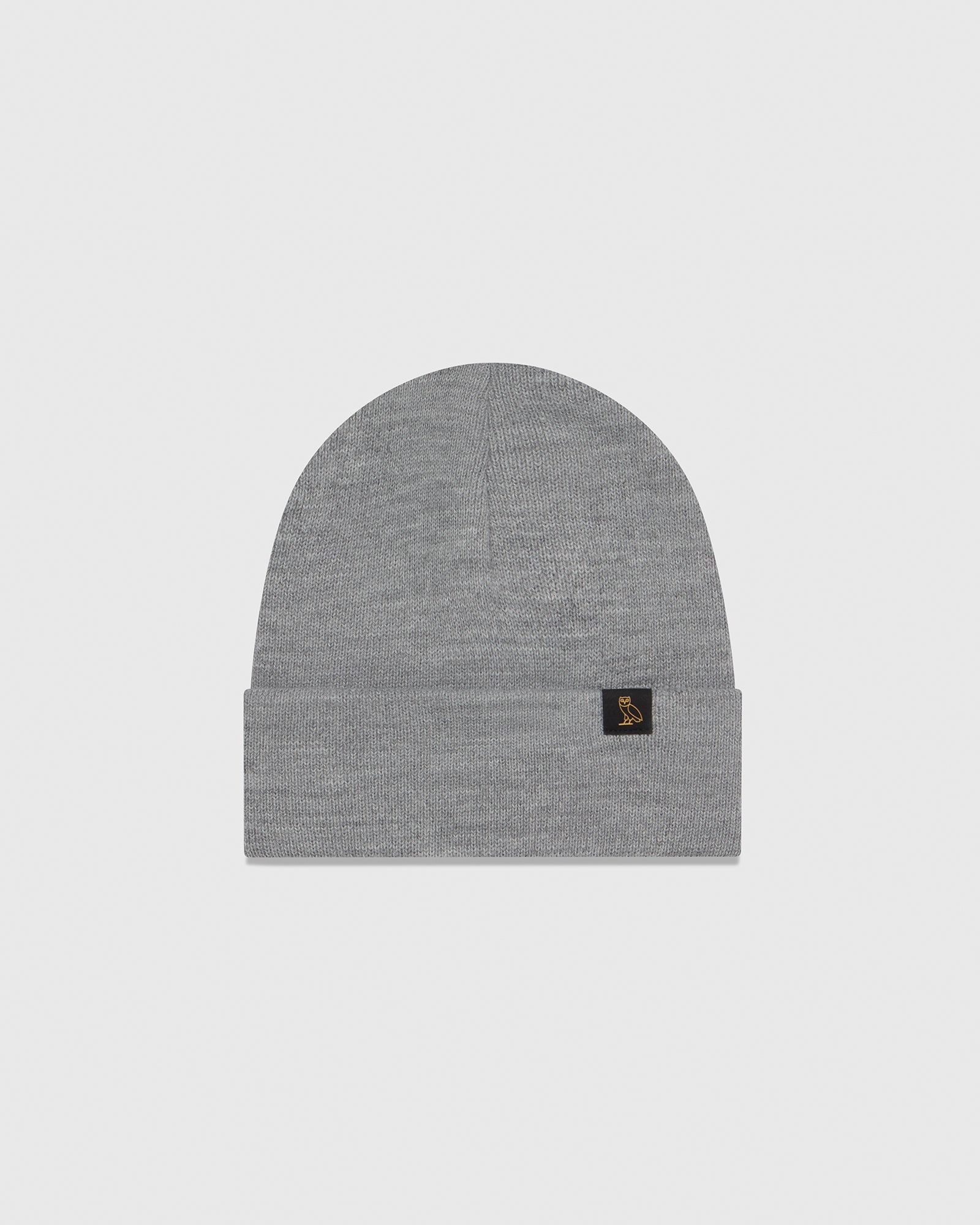 Gray knit beanie with small rectangular logo patch on front cuff.