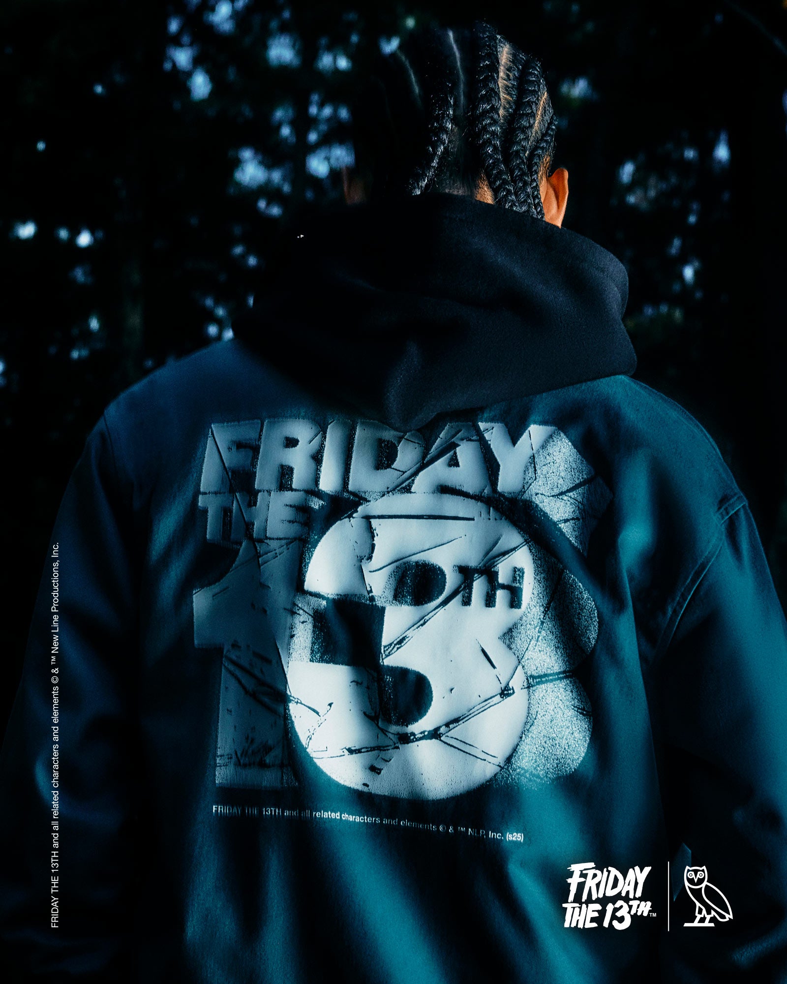 Person wearing a October's Very Own hoodie with 'Friday the 13th' design, dark background