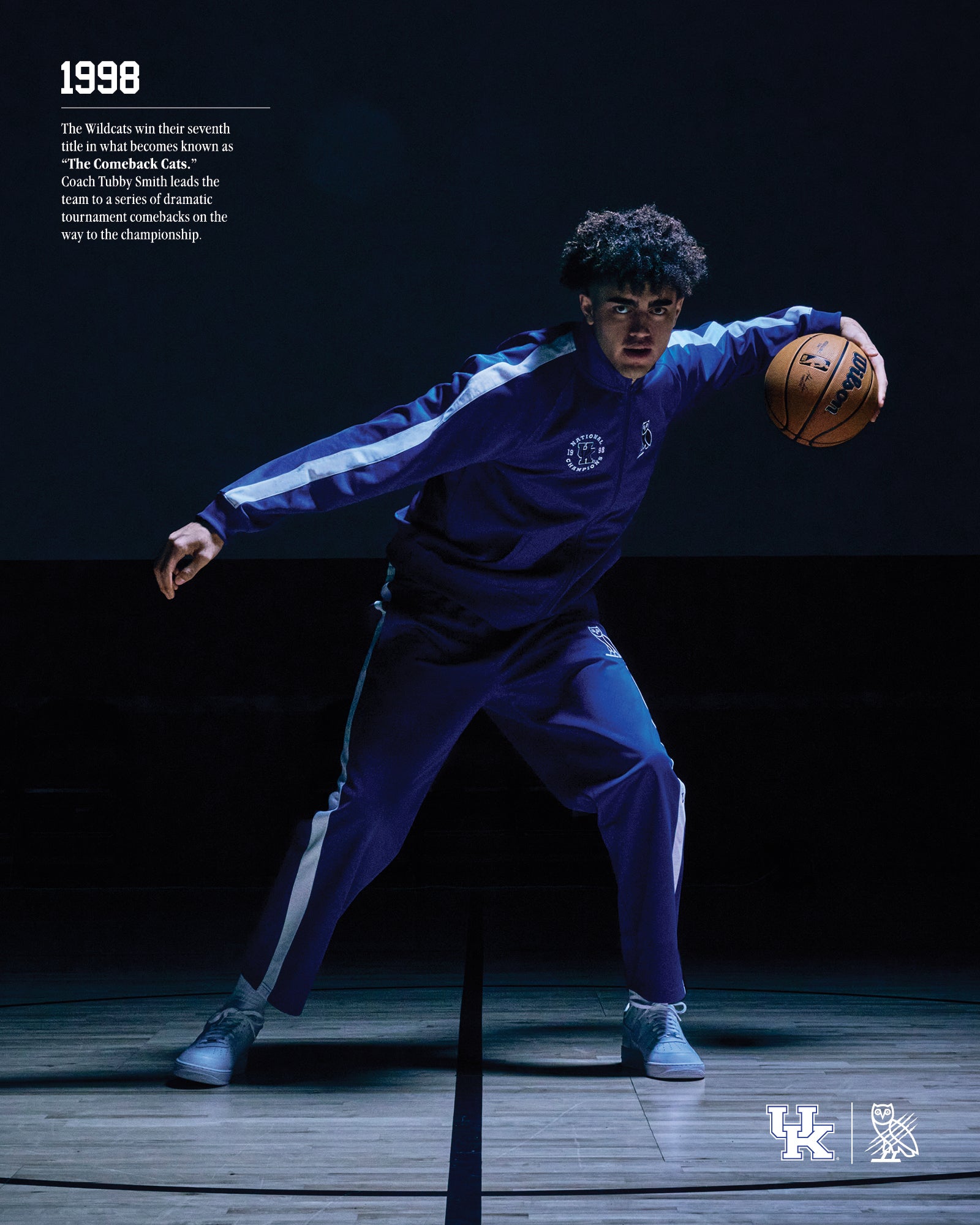 1998. The Wildcats win their seventh title in what becomes known as "The Comeback Cats." Couch Tubby SAmith lead the team to a series of dramatic tournament comebacks on the way to the championship. Person in blue October's Very Own x Kentucky Wildcat tracksuit with basketball on a dark background.
