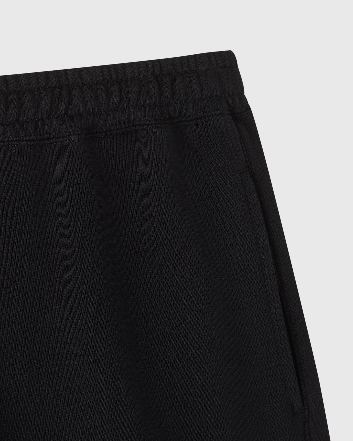 Black sweatshort with elastic waistband and ribbed texture detail.