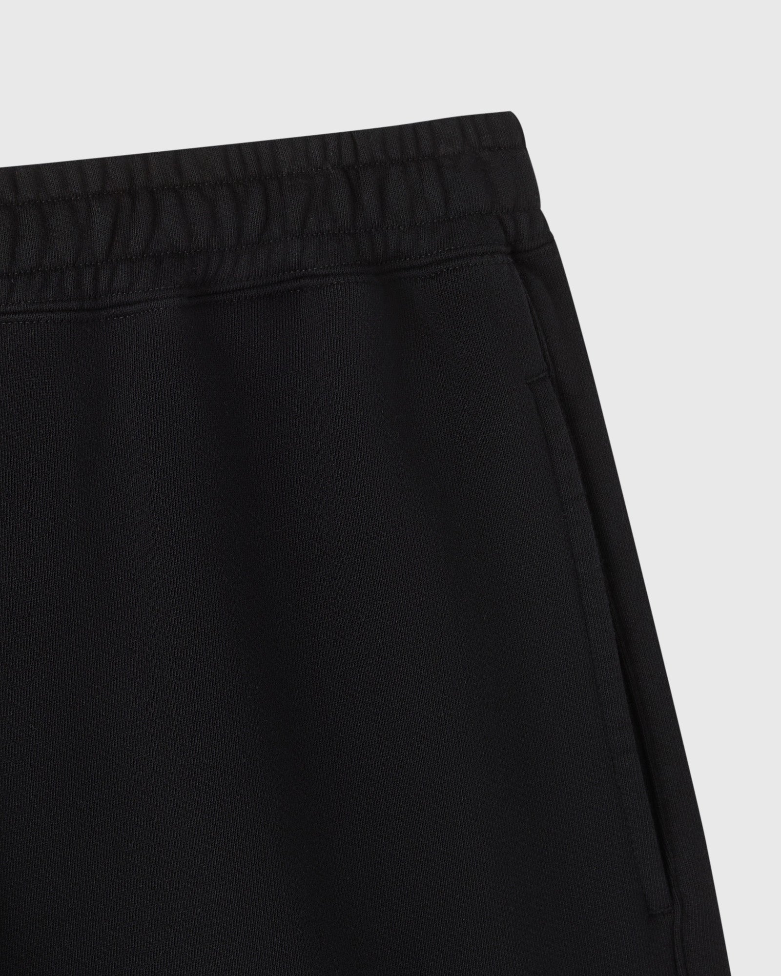 Black sweatshort with elastic waistband and ribbed texture detail.